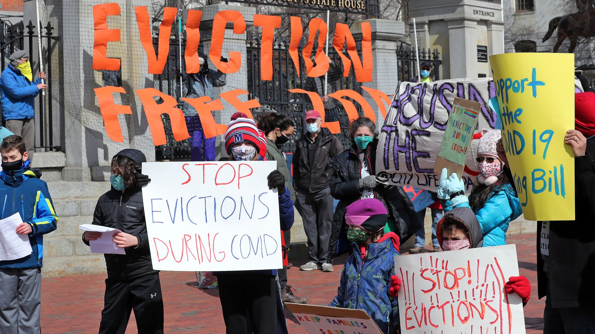 Picture of people holding signs during a protest to support stopping evictions during covid
