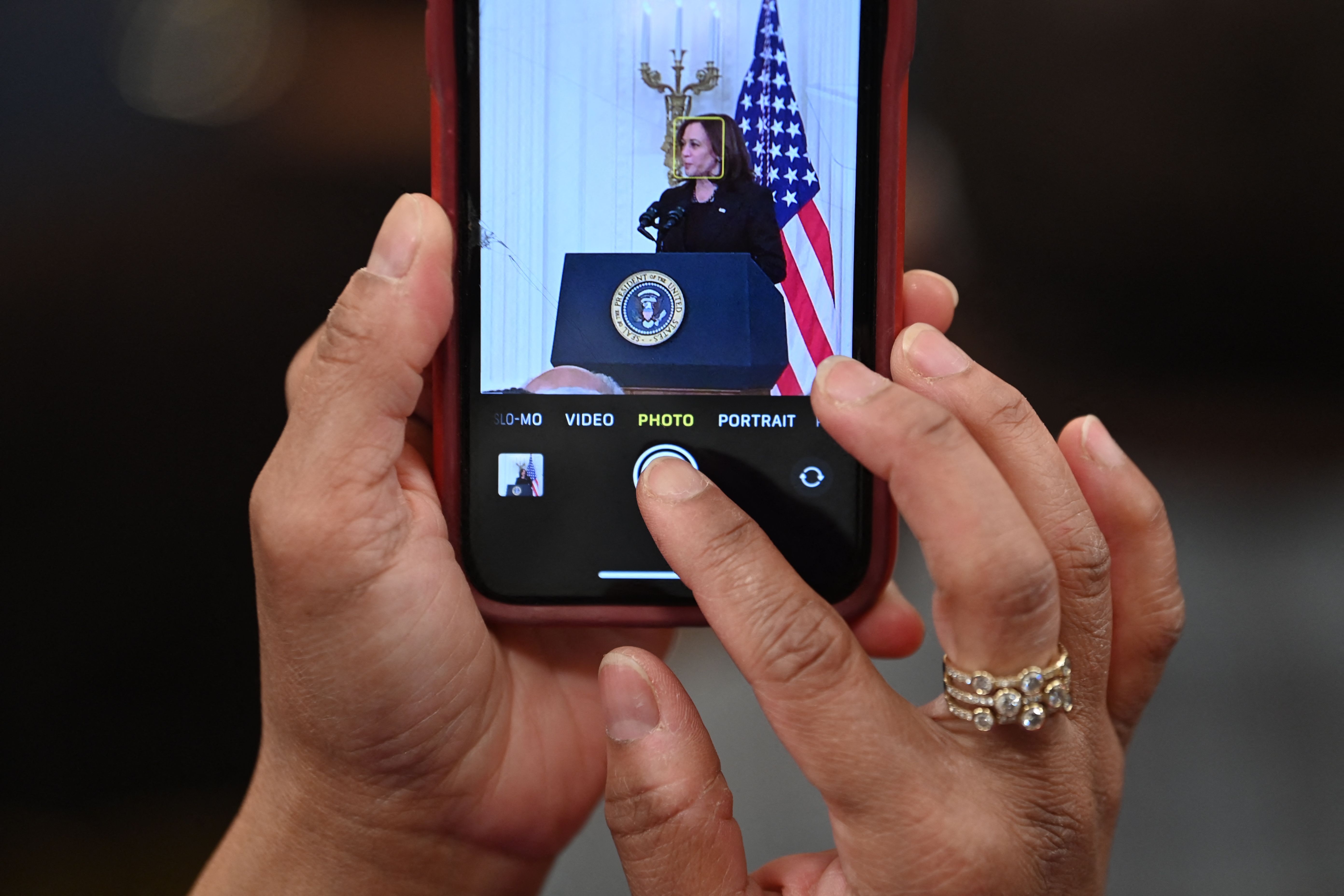 A woman is seen snapping a photo of Vice President Kamala Harris.