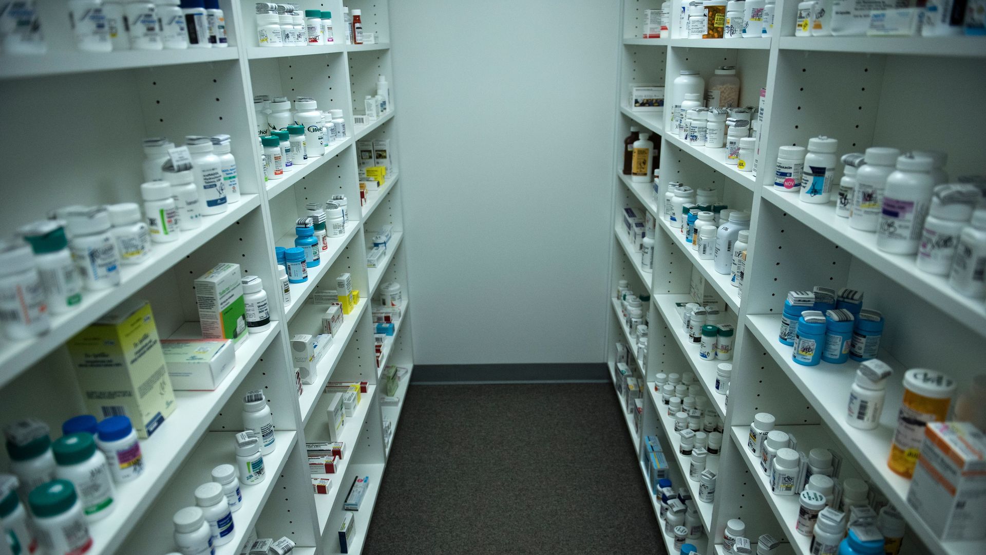 Shelves in a pharmacy are stocked with prescription drugs.