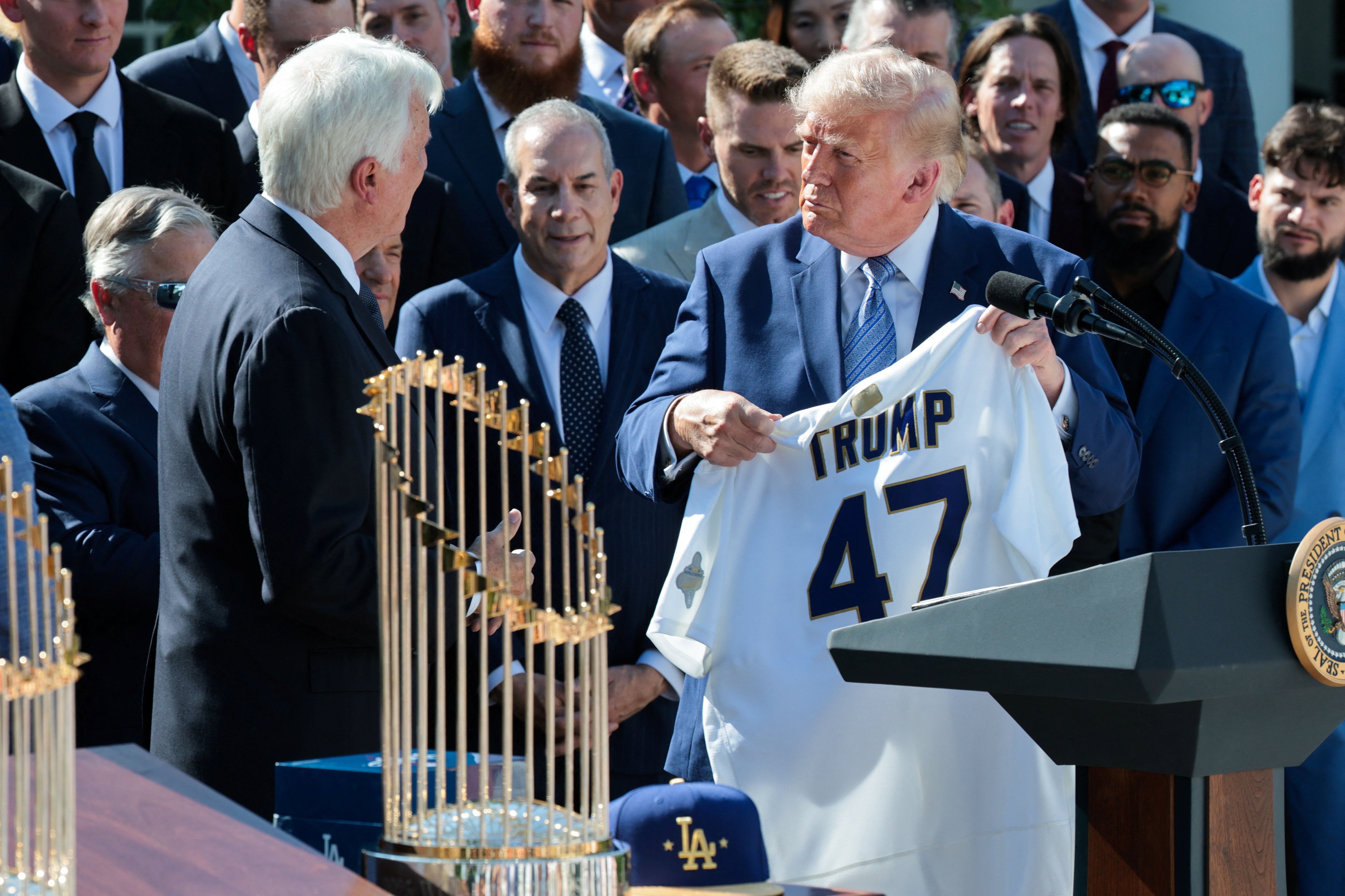 President Trump is gifted a Los Angeles Dodgers jersey during an event to honor the World Series champions at the White House yesterday.