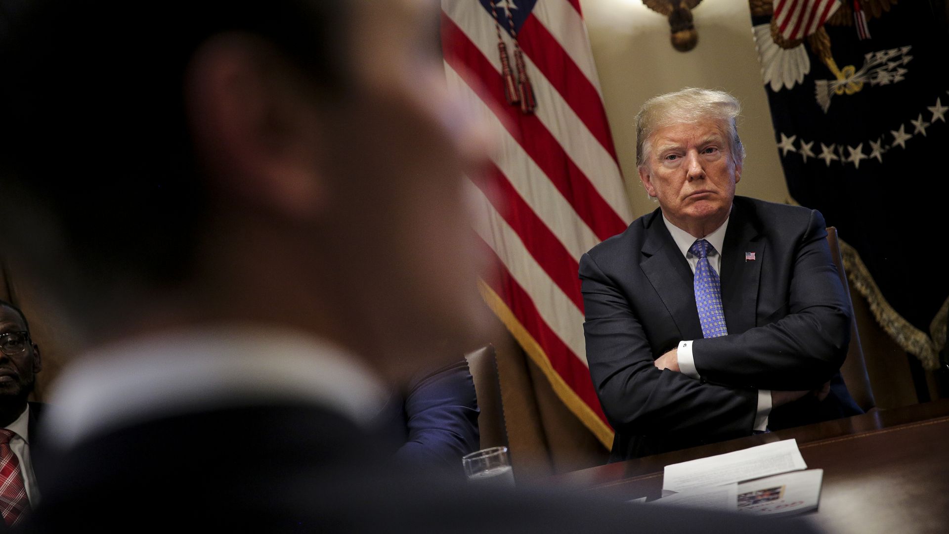 Donald Trump sitting with his arms crossed.