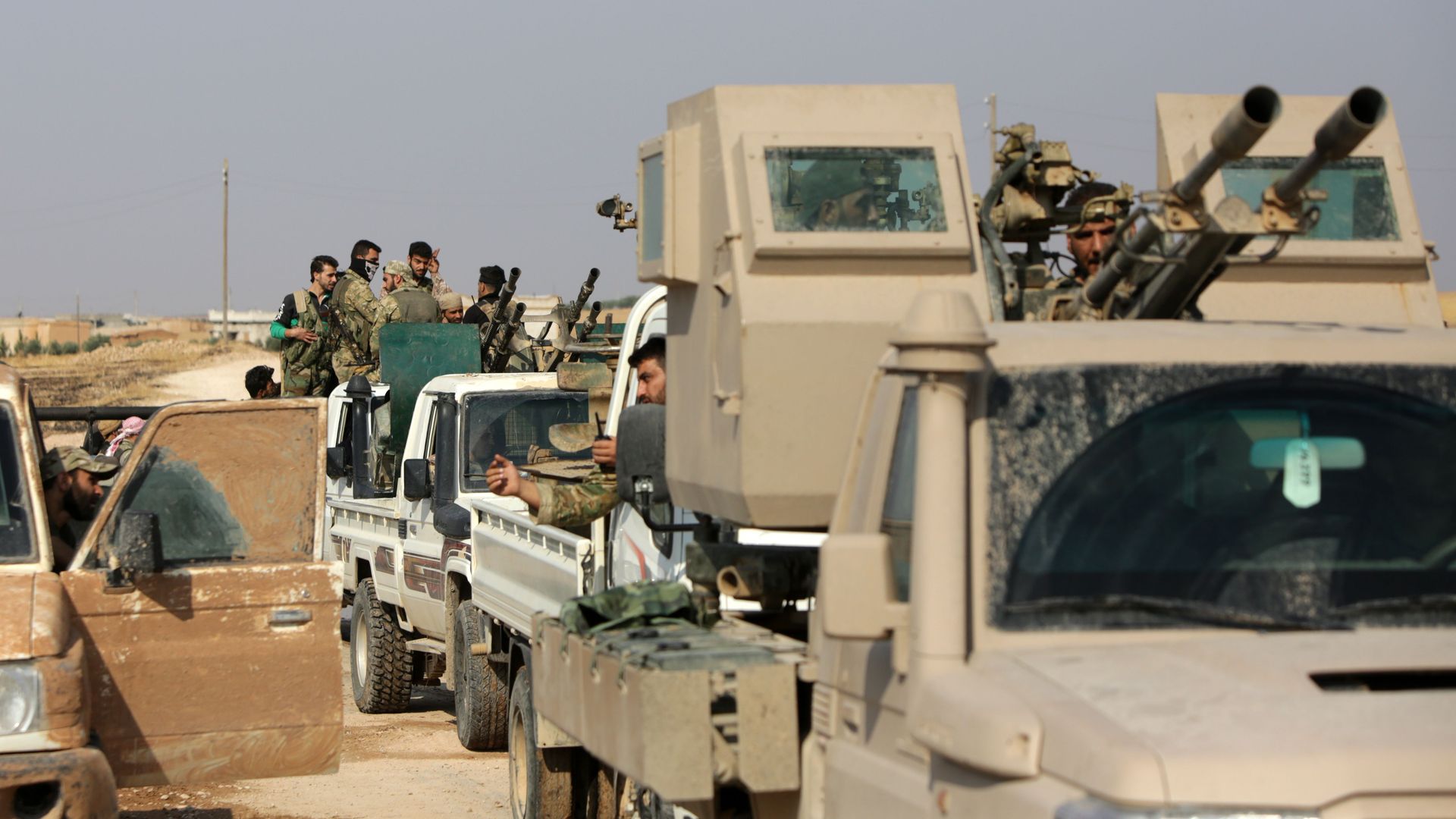 Turkey-backed Syrian fighters gather on a road between the northern Syrian towns of Tal Abyad and Kobane on October 22