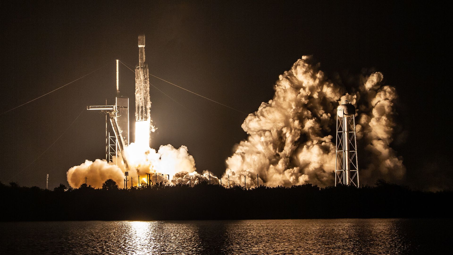 A SpaceX Falcon Heavy rocket launch at night