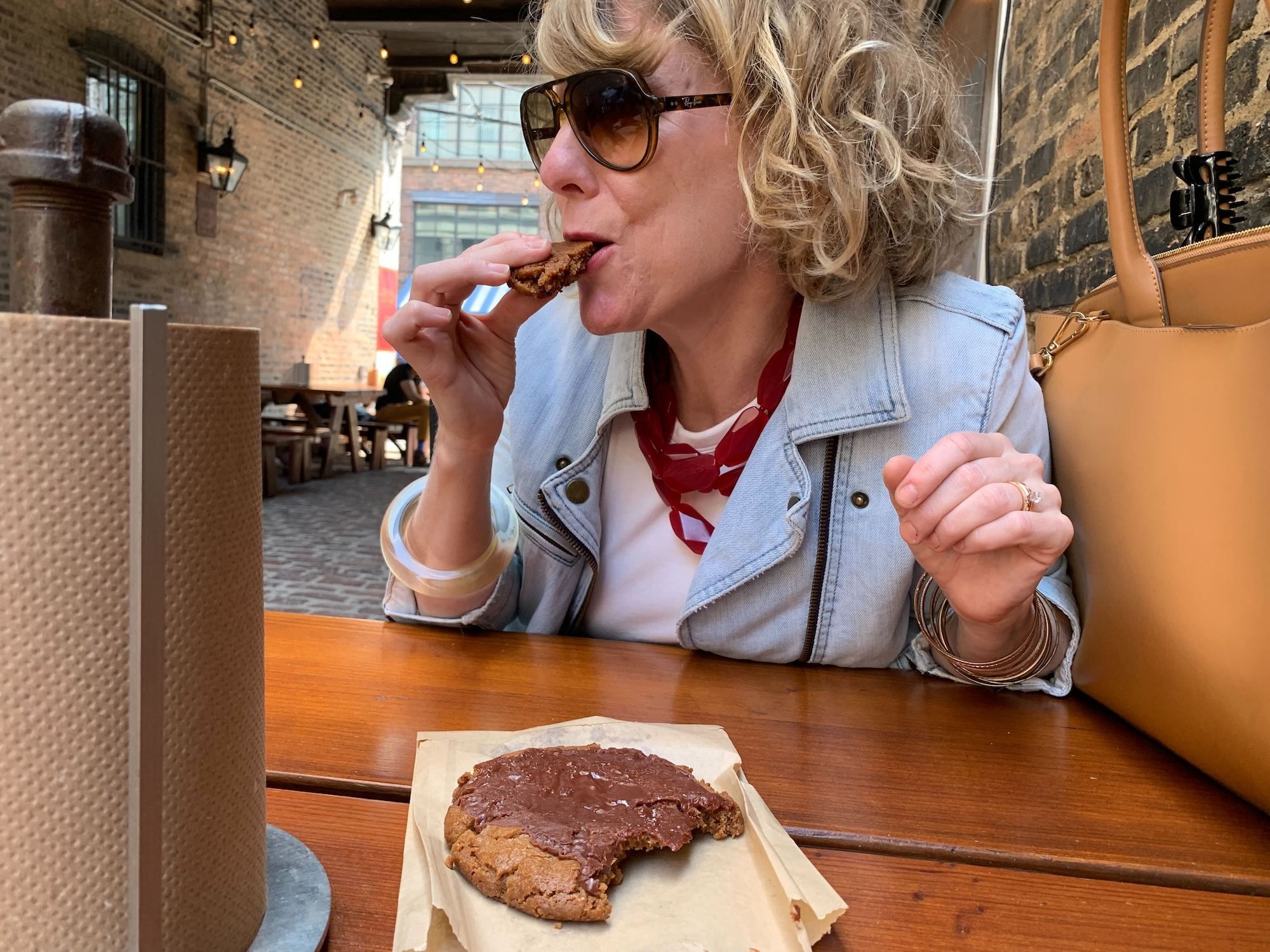 woman eating cookie, wearing sunglasses