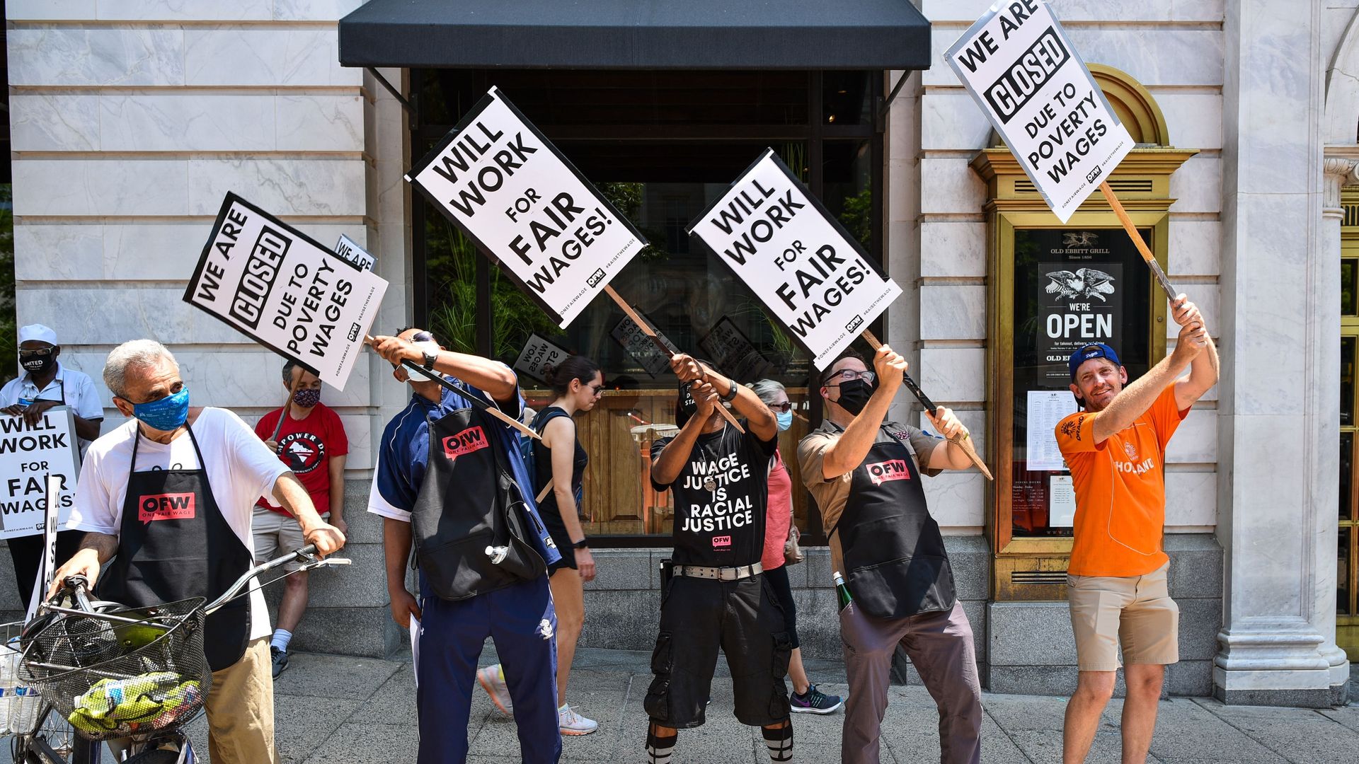 Activists take part in a protest outside of the Old Ebbitt Grill to call for a full minimum wage with tips for restaurant workers in Washington, DC