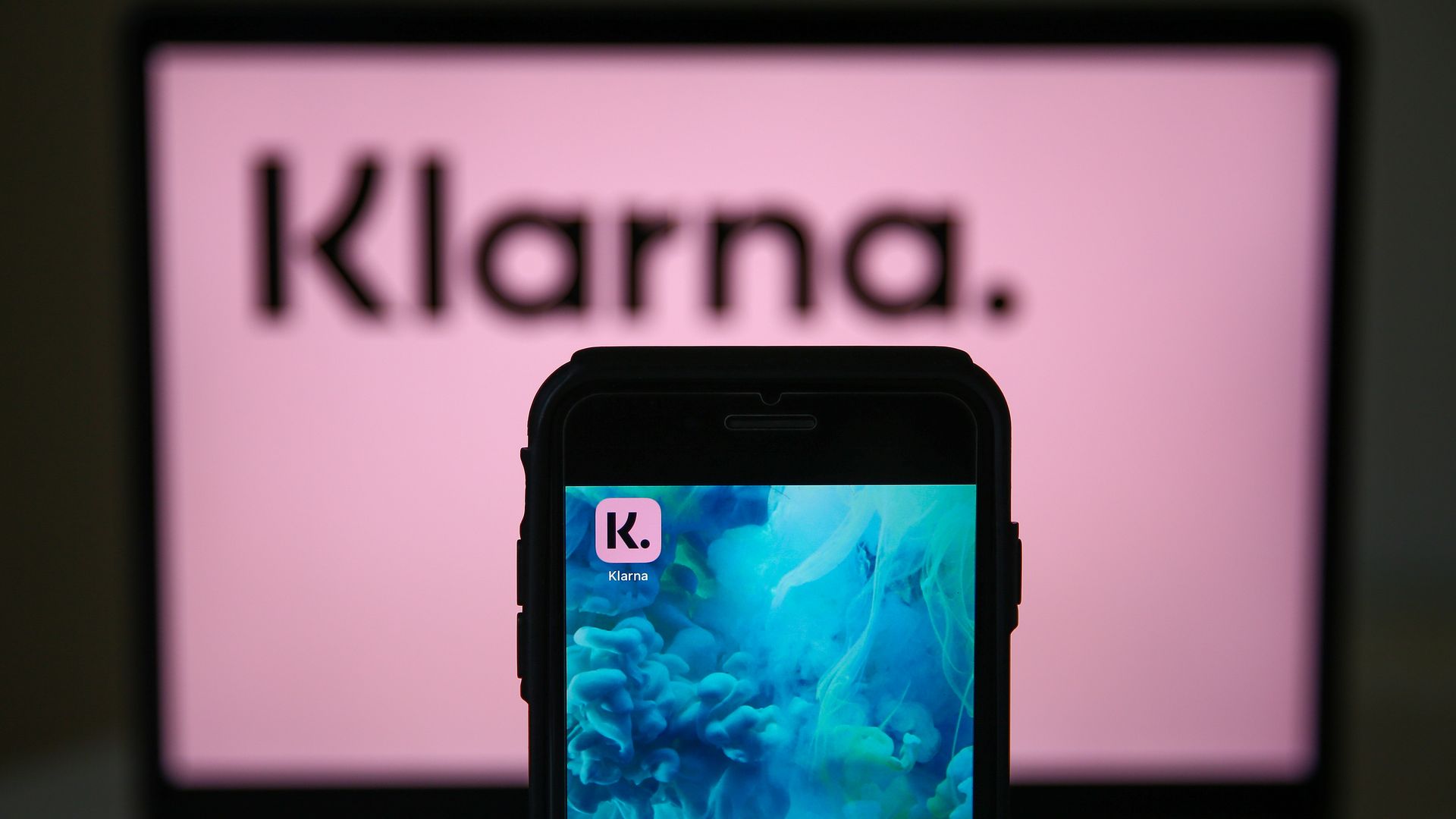 The Klarna logo seen on a desktop and a phone 