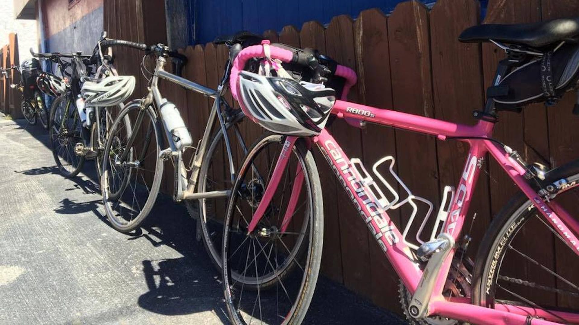 A helmet on a bike leaning against a building 