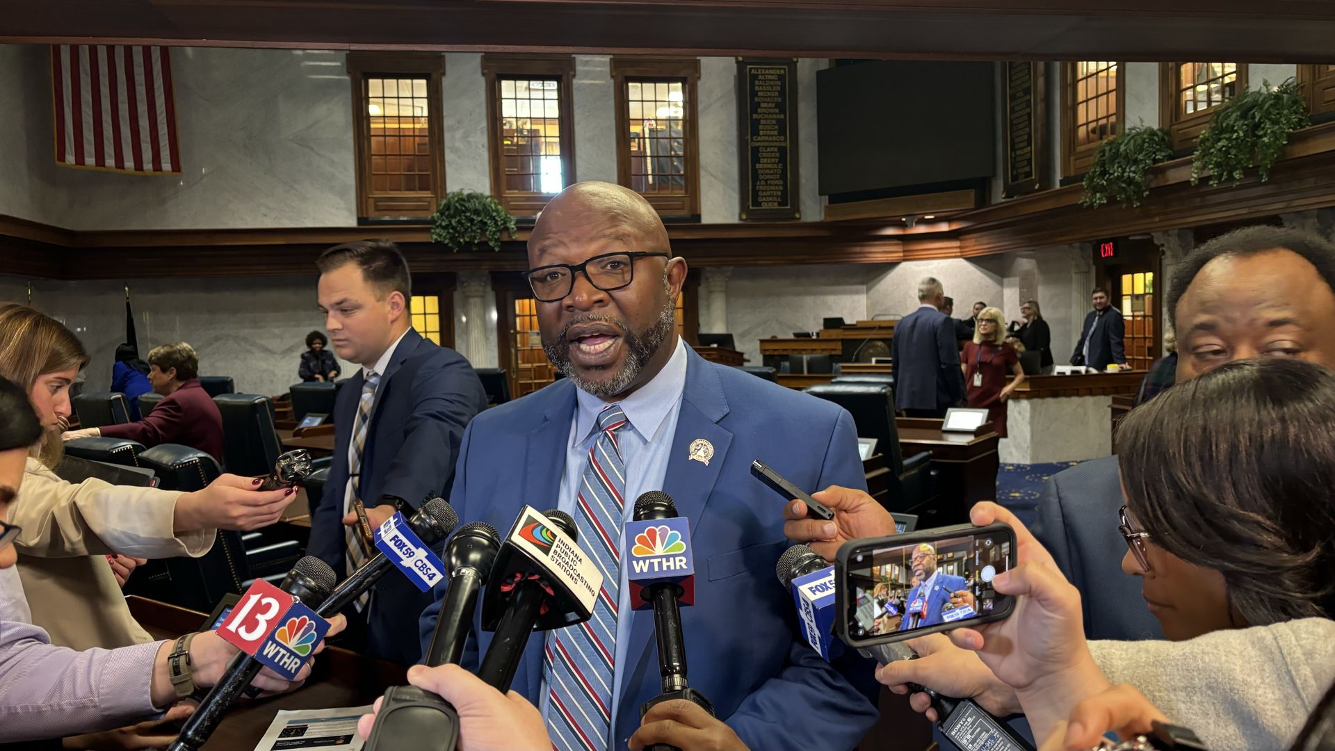 A man talking in front of reporters