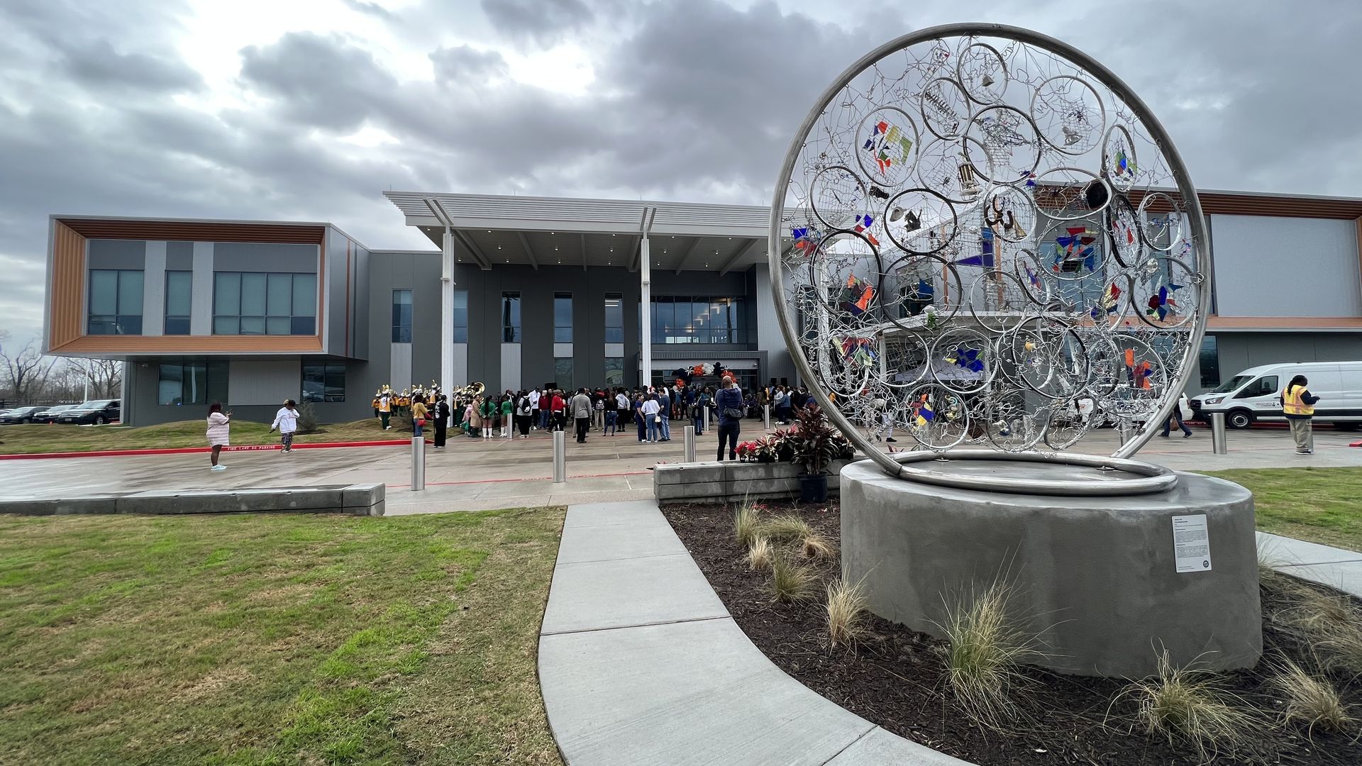 A art piece of a large dream catcher is in the foreground of a photo of the new Sunnyside health and multi-service center 