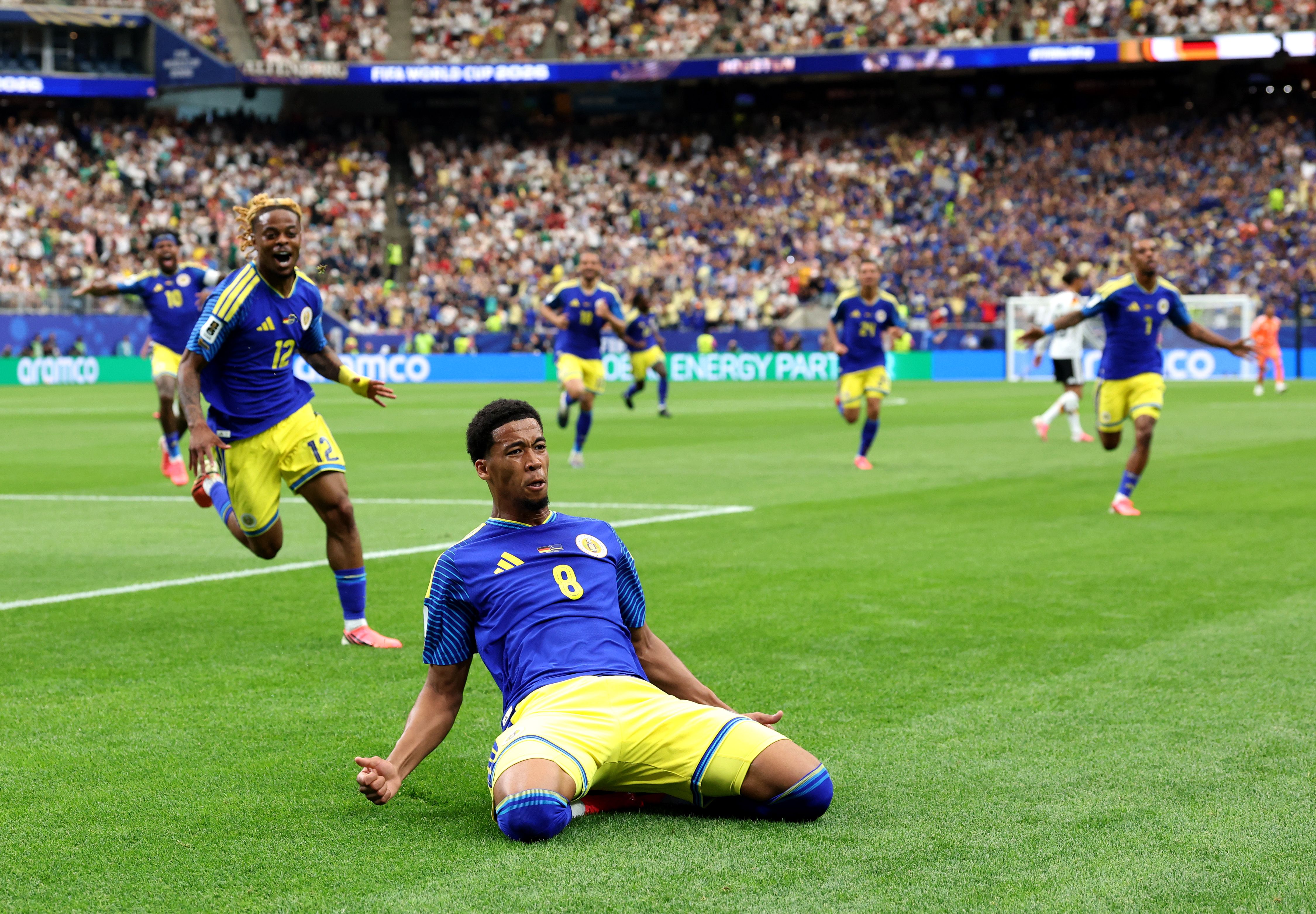 Player 8 celebrates on the pitch inside stadium.