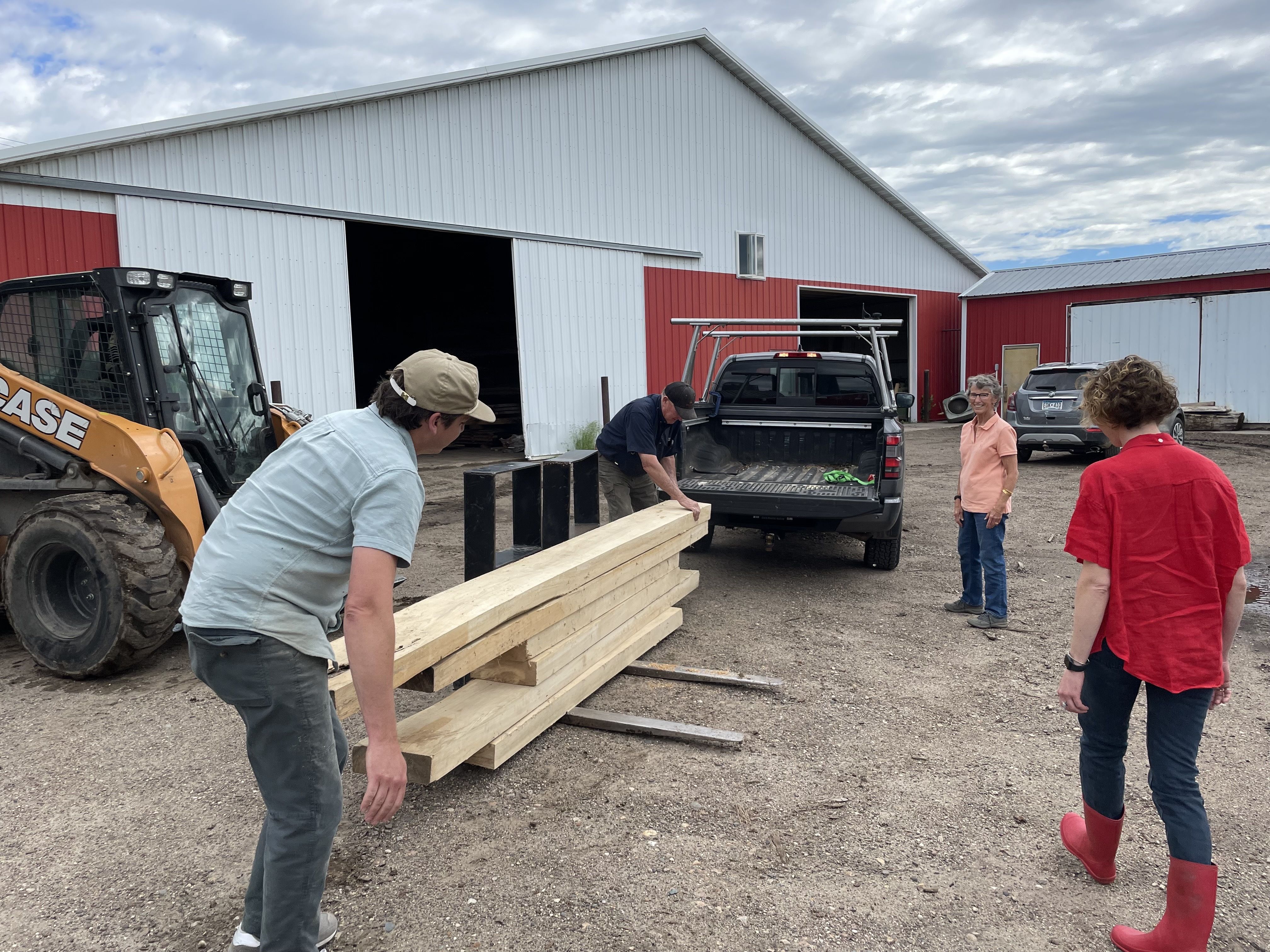two men bringing boards out of a truck