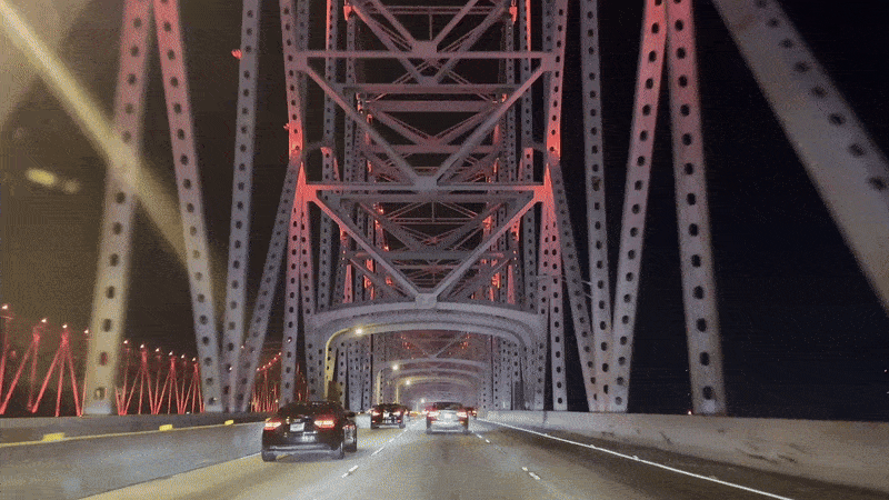 Cars drive under the beams of the Crescent City Connection.