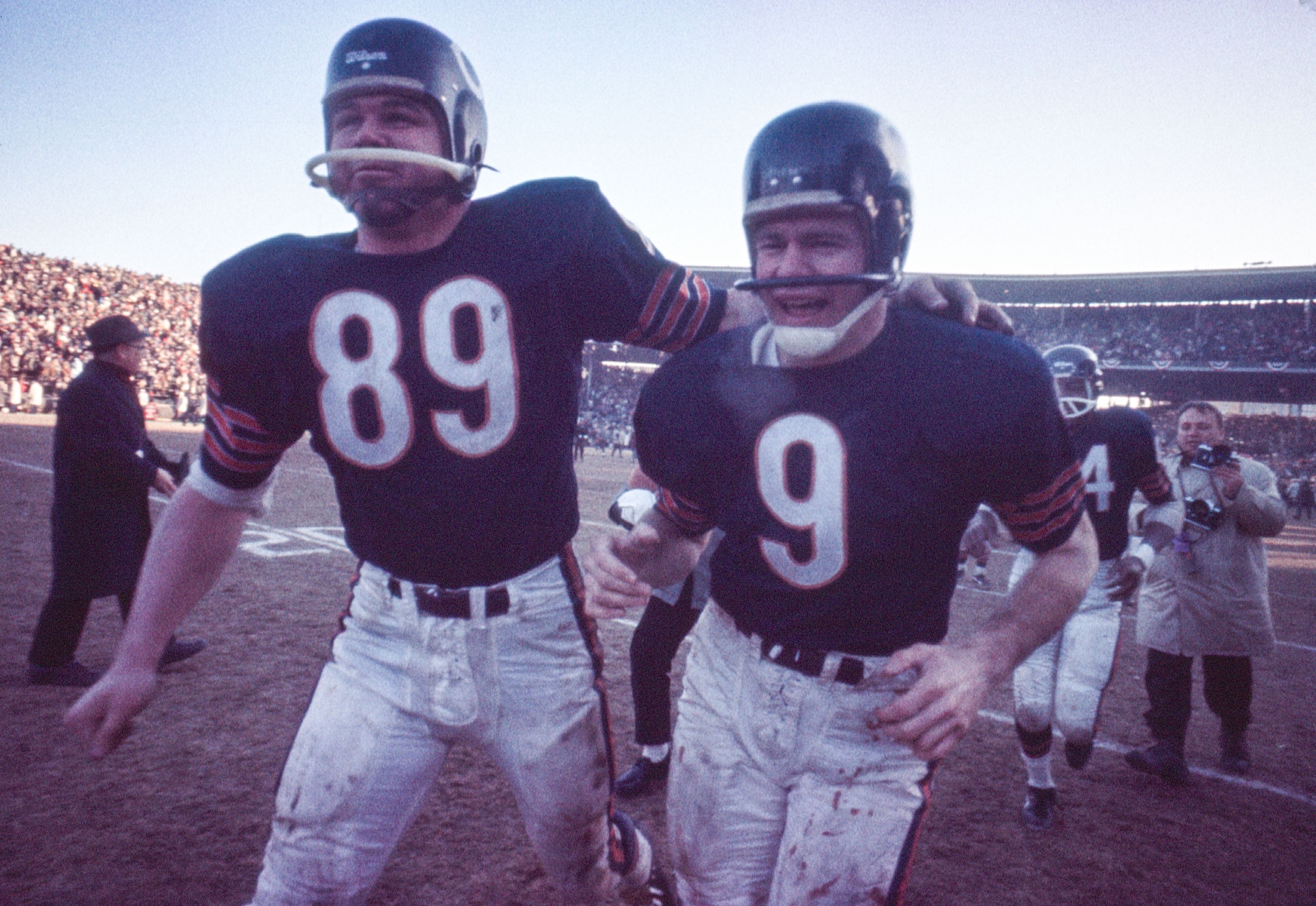 Photo of two football players walking off field after a game 
