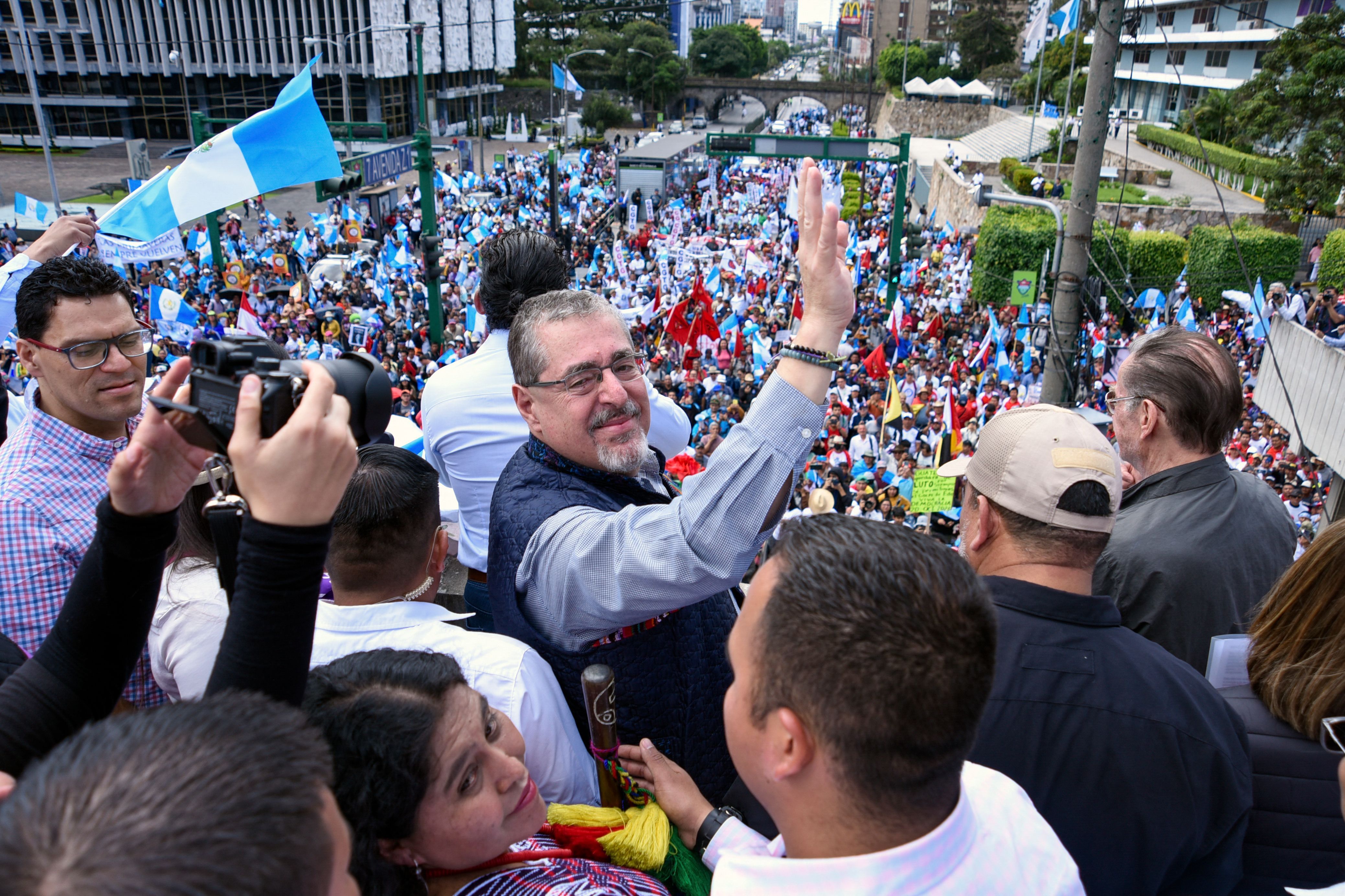 Guatemalan President-elect Bernardo Arévalo waves and smiles at a crowd during massive protests against the country's attorney general