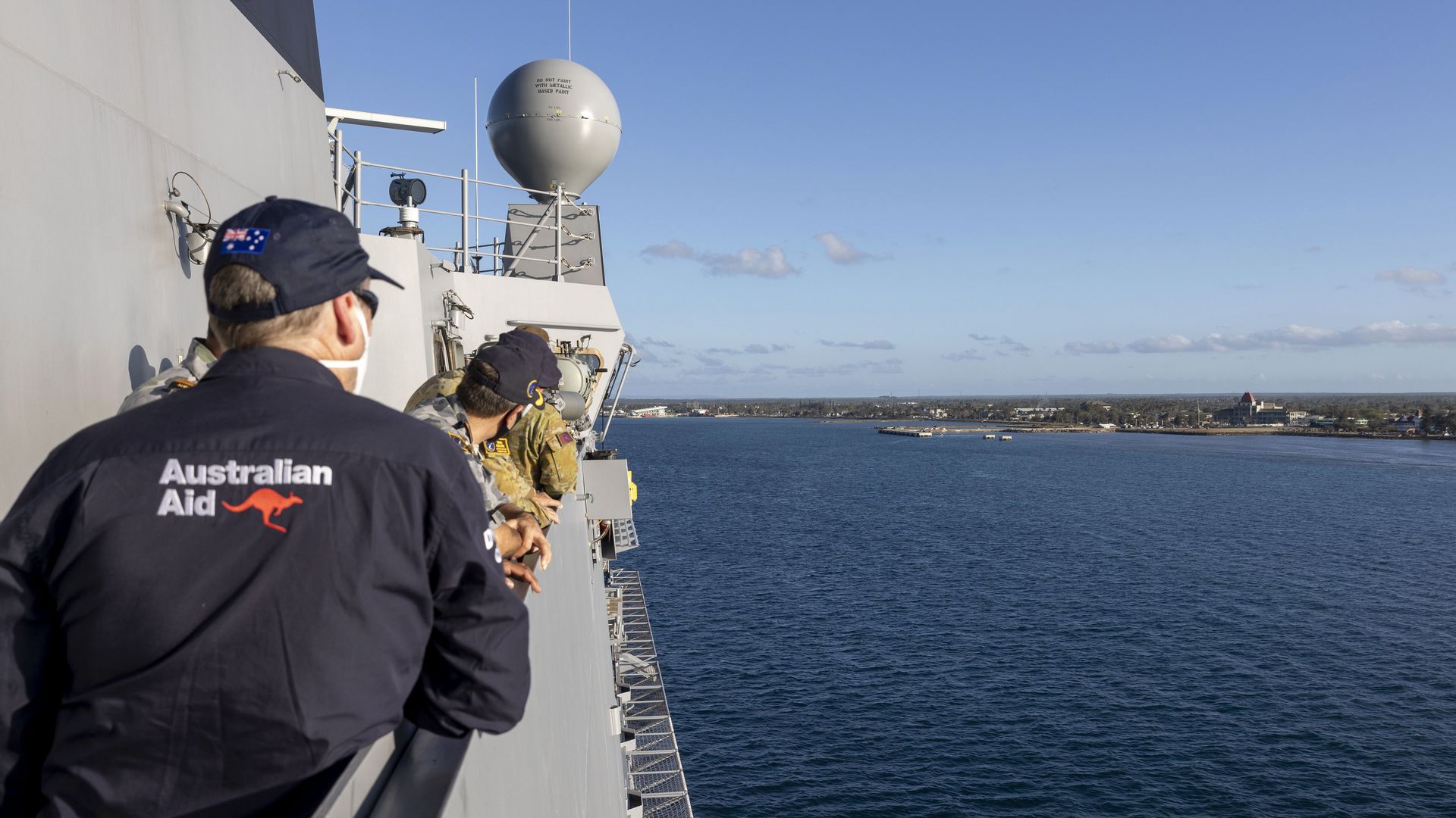 Australian crew on board HMAS Adelaide watch as the ship arrives in Nuku'alofa, Tonga, Wednesday, Jan. 26, 2022, carrying disaster relief and humanitarian aid supplies. 