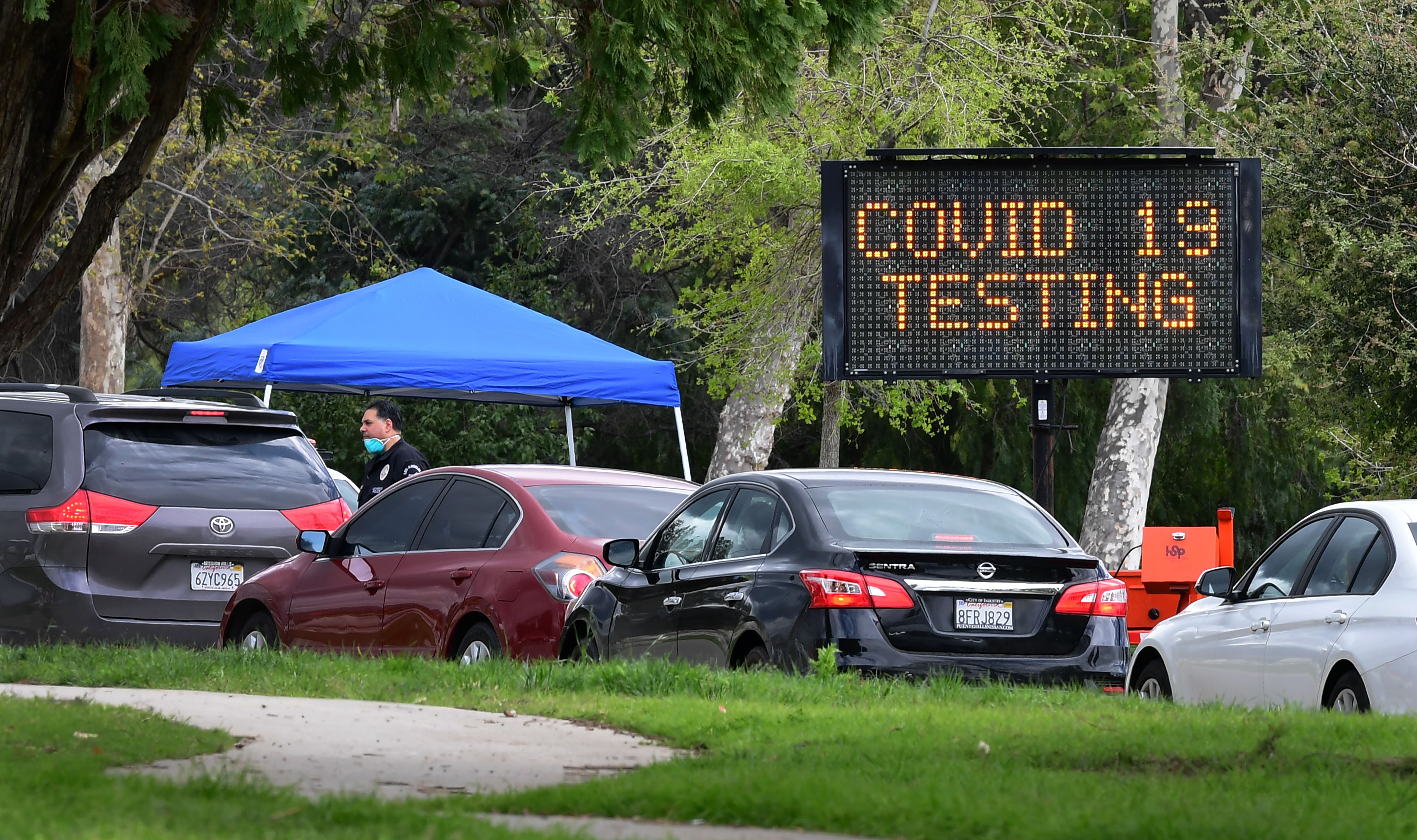 A police officer mans the entrance to a coronavirus (COVID-19) testing center in Hansen Dam Park on March 25