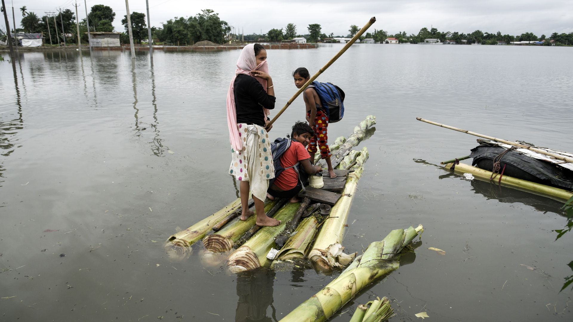 People escaping flooding on a raft in Barpeta, India, on June 17.
