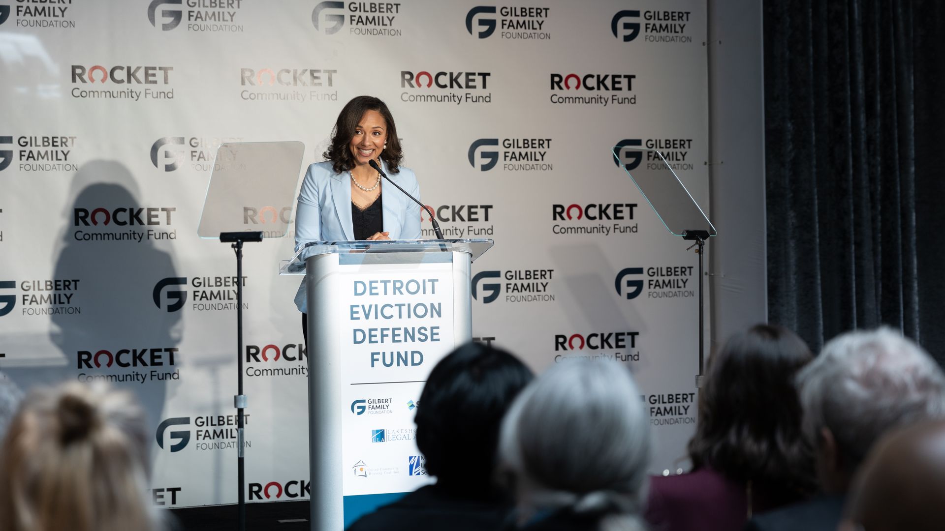 Council President Mary Sheffield smiles while speaking at a lecturn.