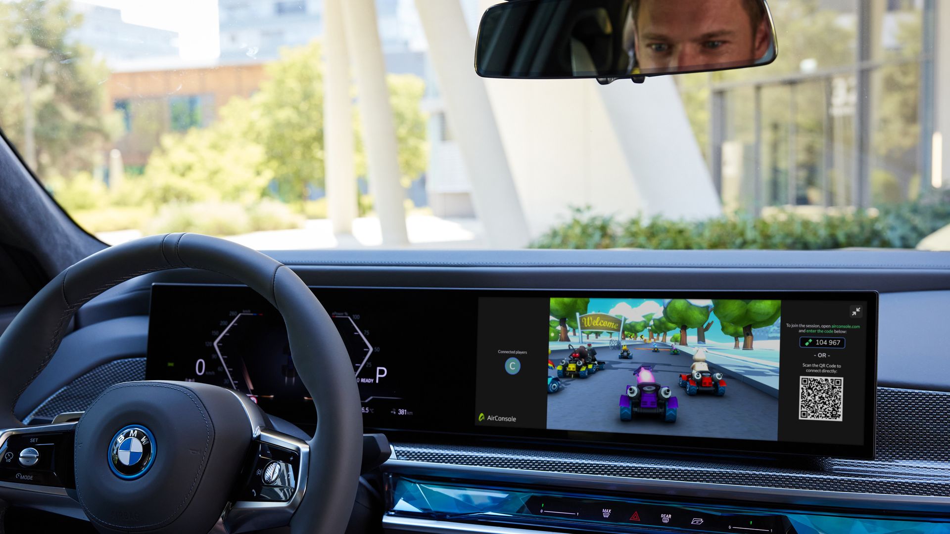 Photo from inside a car,  showing a racing video game running on a screen next to the steering wheel.