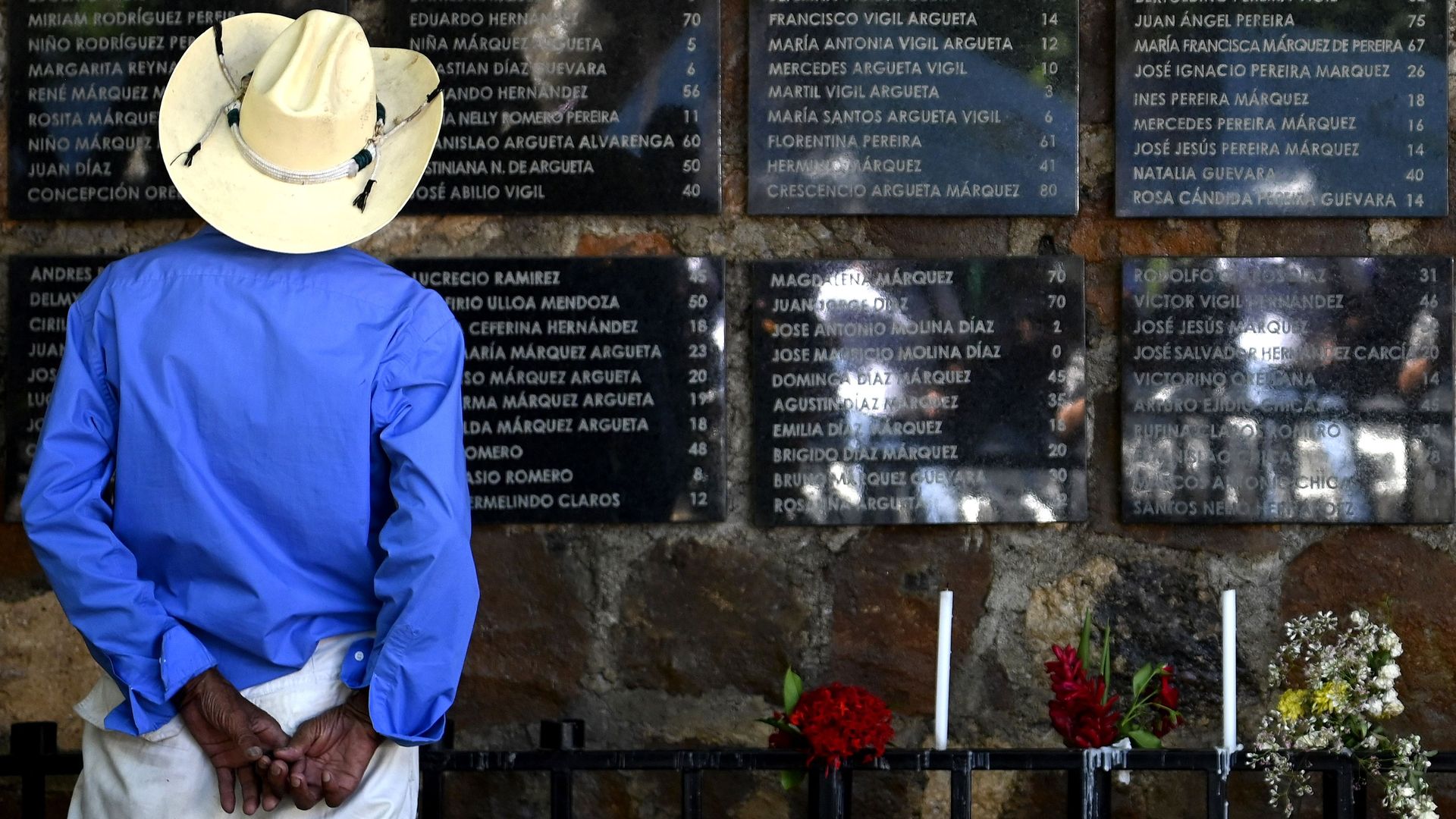 A man reads the names of the victims of the El Mozote, El Salvador, on a memorial commemorating the massacre.