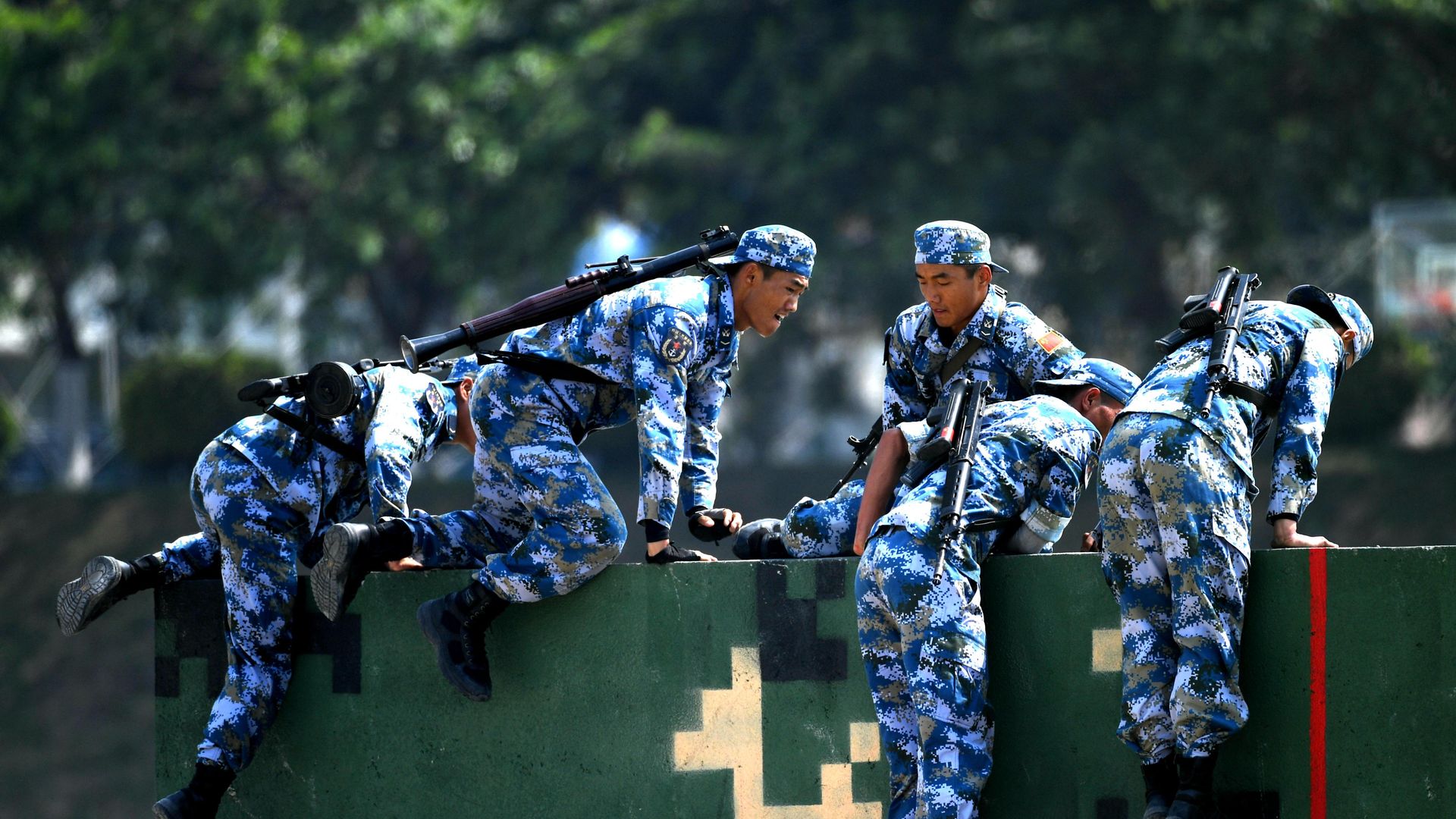 Chinese marines climbing over obstacle course as they participate in an international exercises