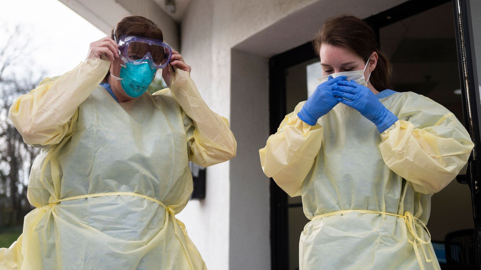Health care workers from Virginia Hospital Center put on their personal protective equipment before people arrive at a drive through testing site for coronavirus in Arlington, Virginia.