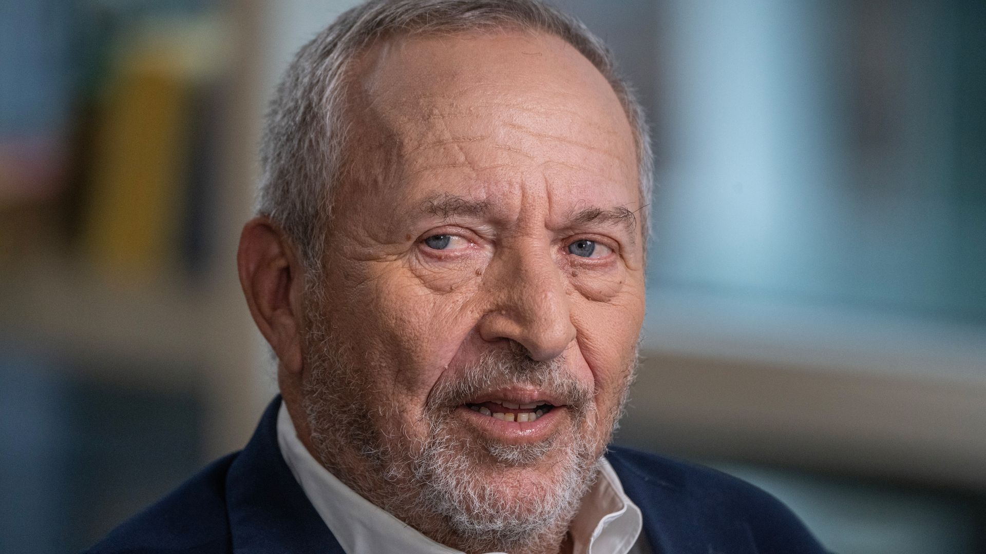 Larry Summers, a balding, bearded gray-haired president emeritus and professor at Harvard University, stares to the right while wearing a navy jacket and white, open-collar shirt during a September interview in New York . 