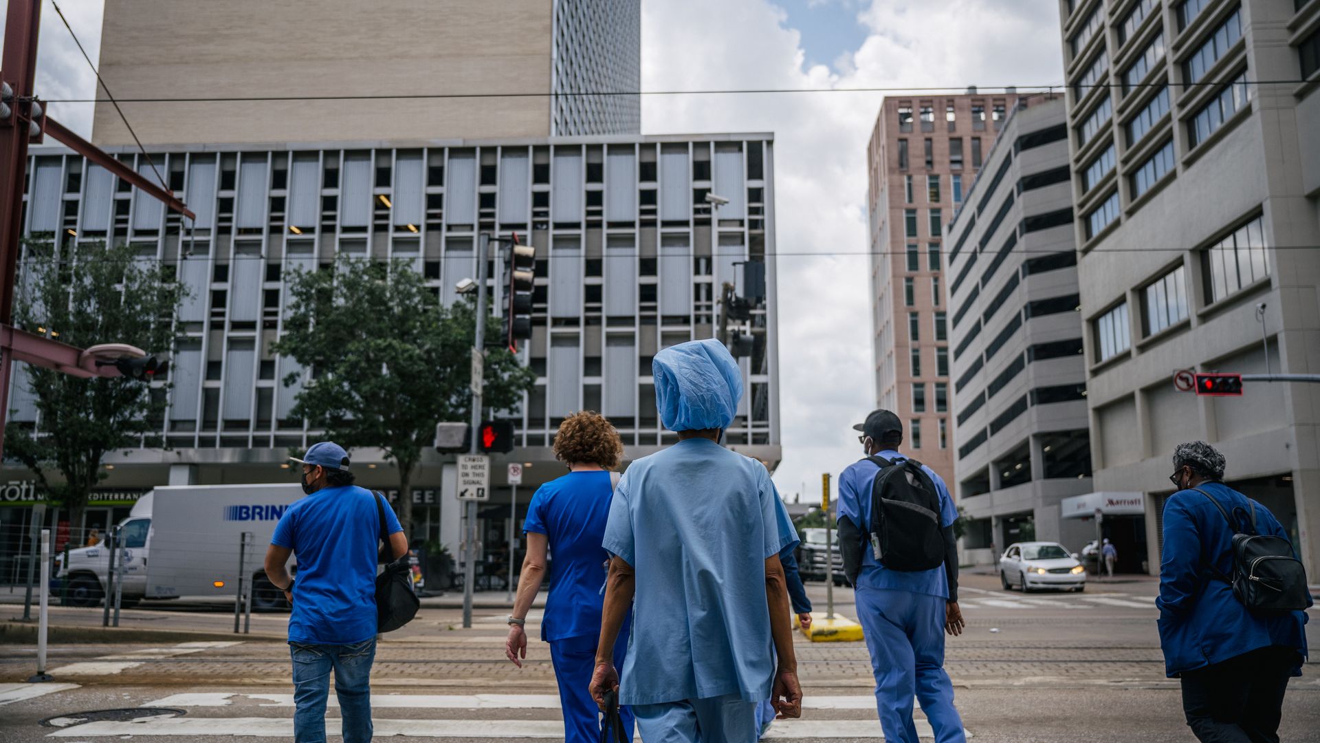 Medical workers and pedestrians cross an intersection outside of the Houston Methodist Hospital on June 09, 2021 in Houston, Texas.