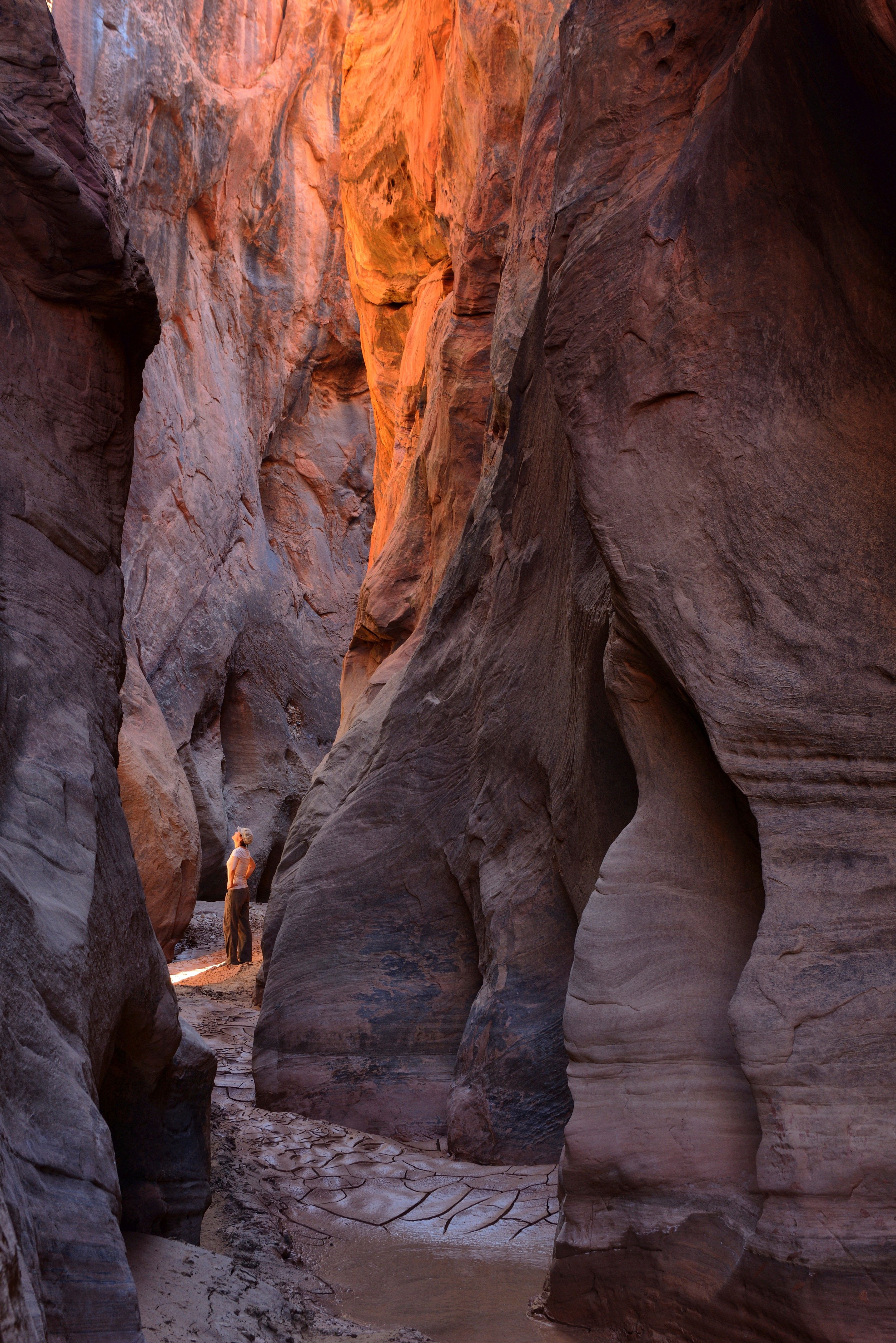 A hiker in a red rock slot canyon 
