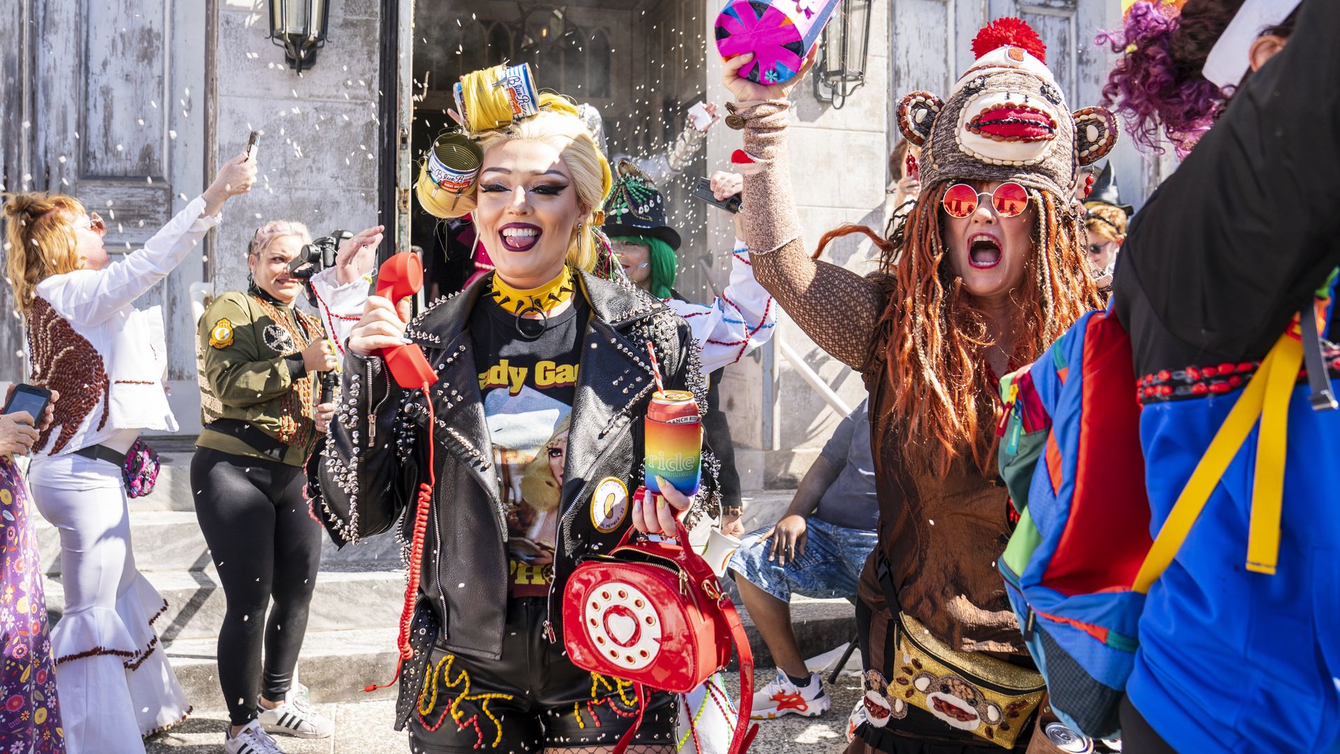 Two people in bean-covered costumes walk through a crowd.