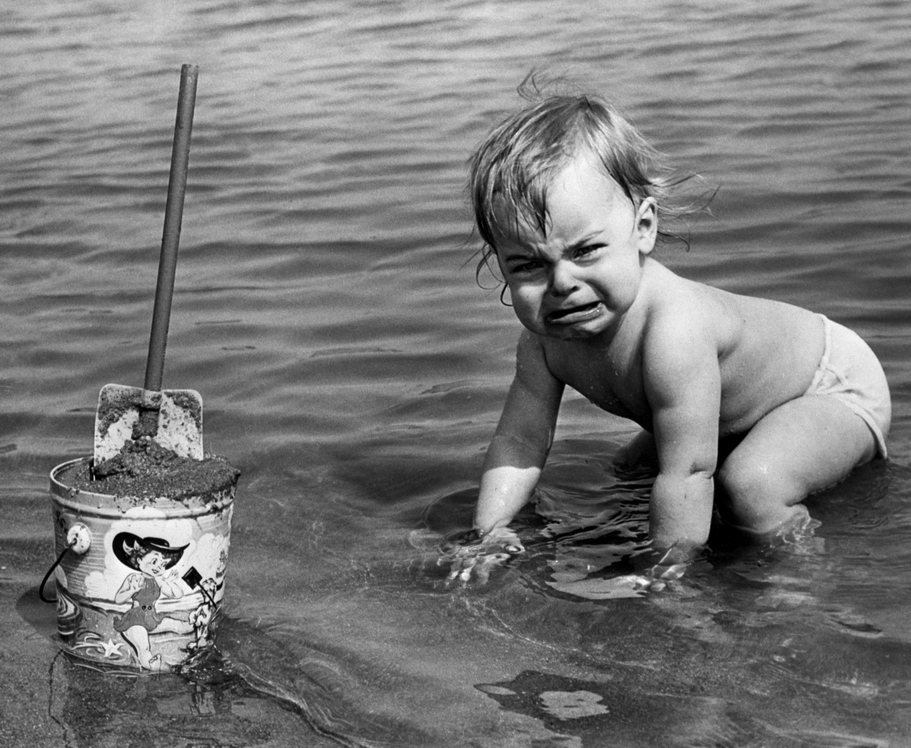 Baby on beach with a pail 