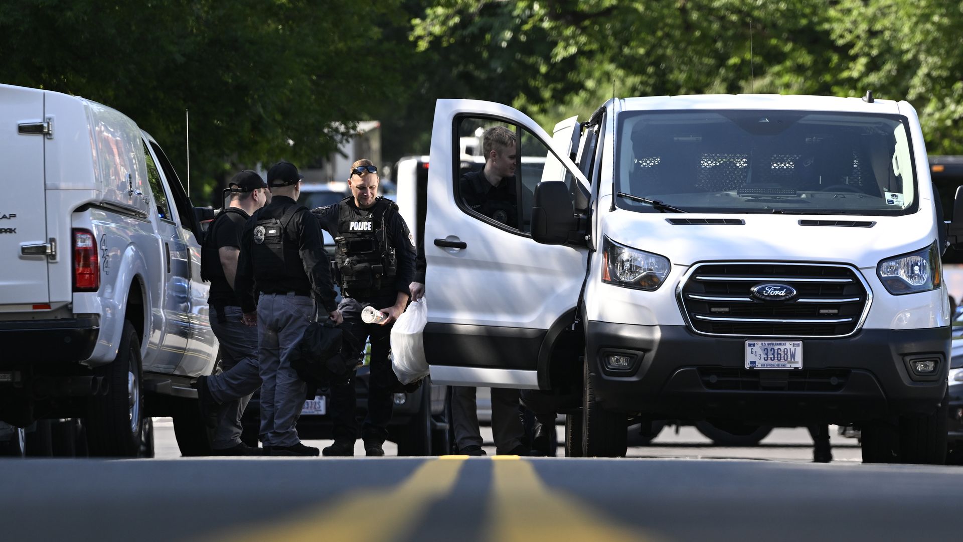 Police officers stand next to white vans on a closed road outside the RNC.