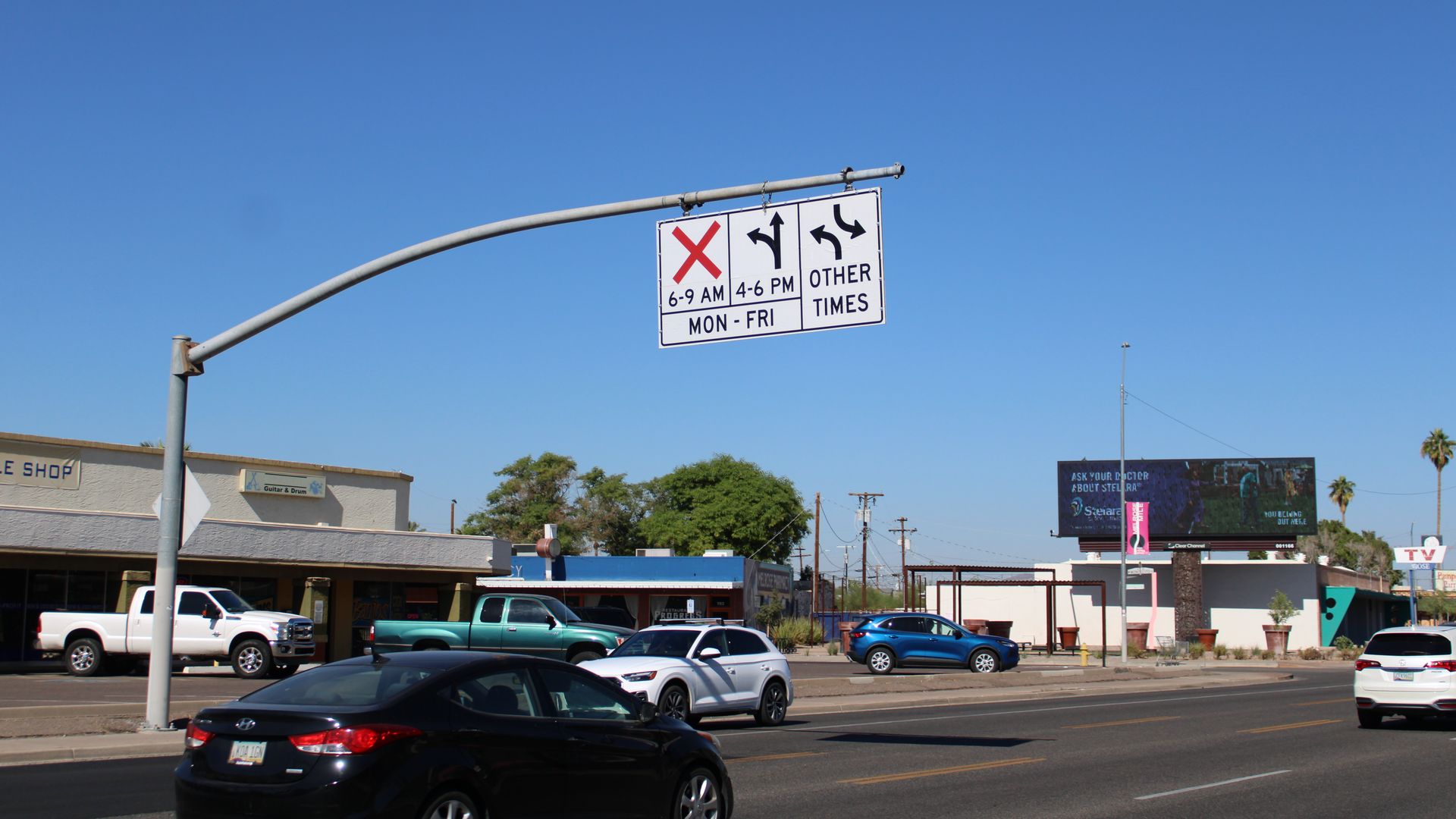 A traffic sign hanging over a busy road. 
