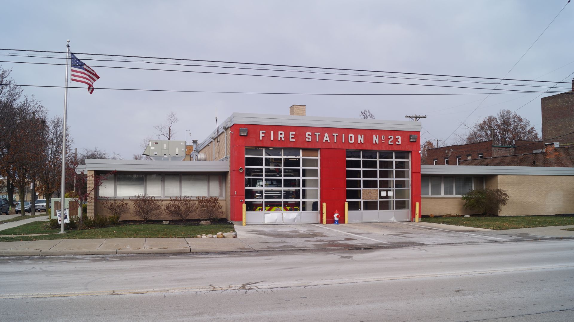 Photo of red fire station No. 23 with American Flag to the left on pole