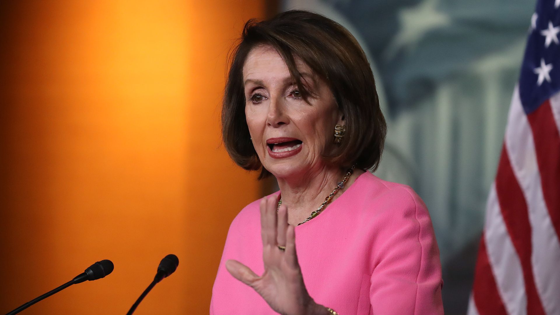 In this image, Pelosi speaks while standing near an American flag.