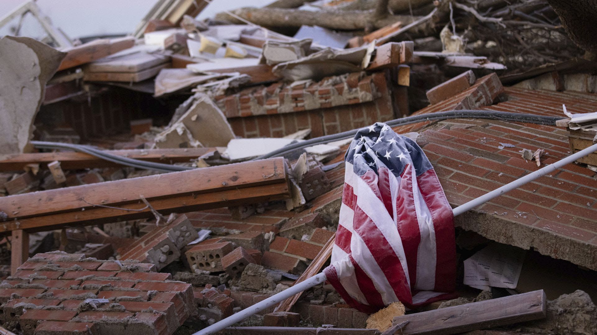 An American flag draped over debris after a tornado in Dawson Springs, Ky.