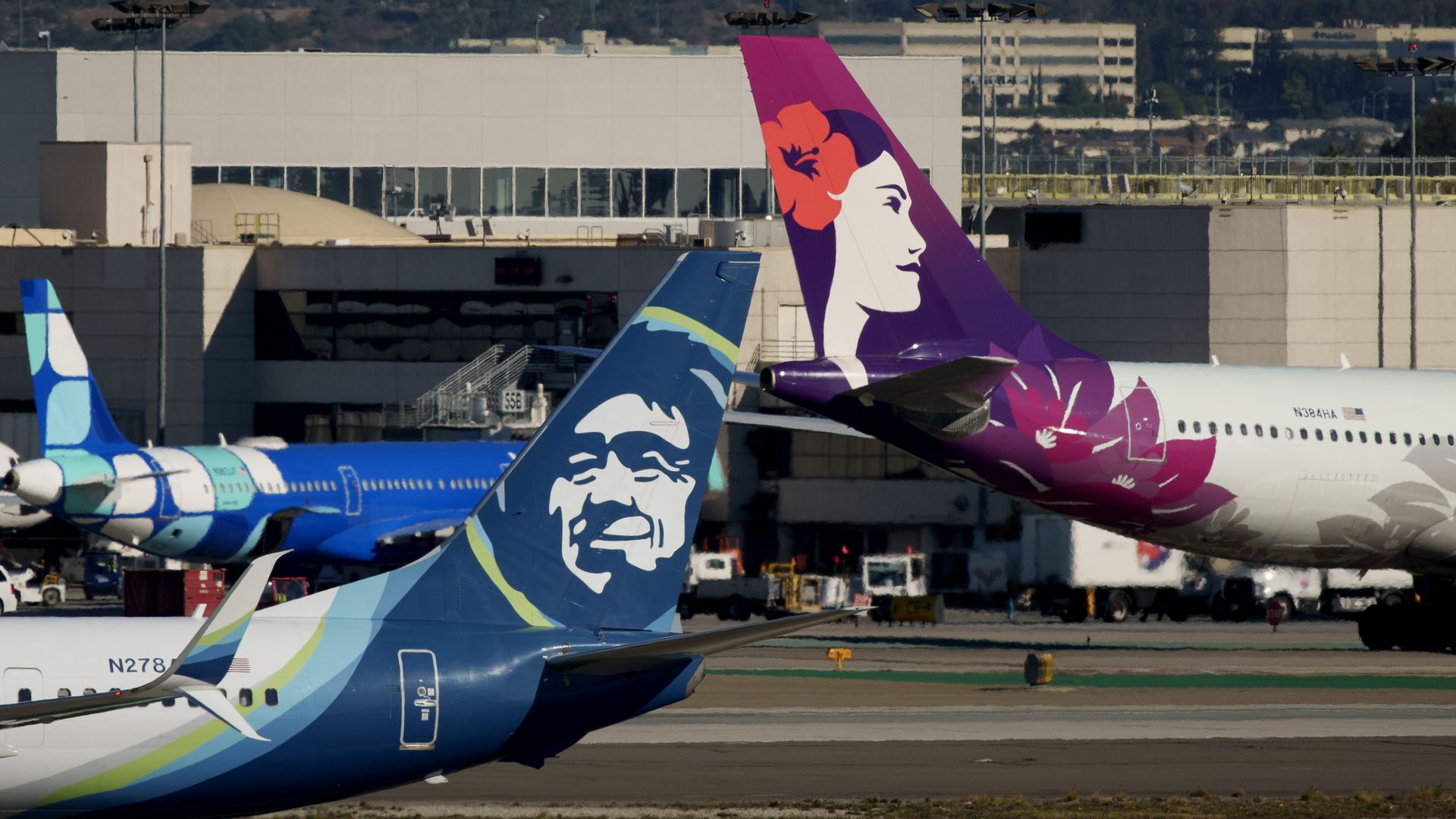 Two airplane tails on a tarmac.