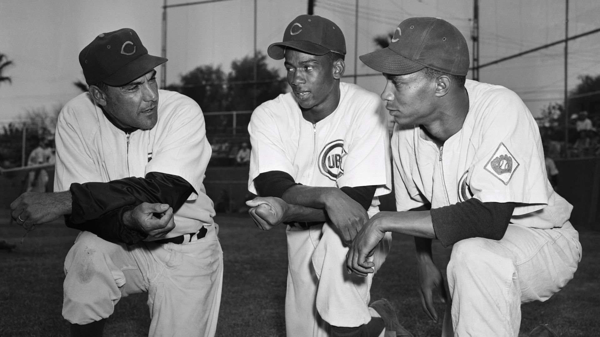 Photo of three baseball players kneeling. 