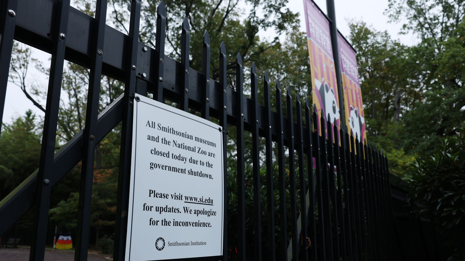 A sign with a notice of closure, citing the government shutdown, is seen pinned on the fence to the National Zoo on October 12, 2025 in Washington, DC. 