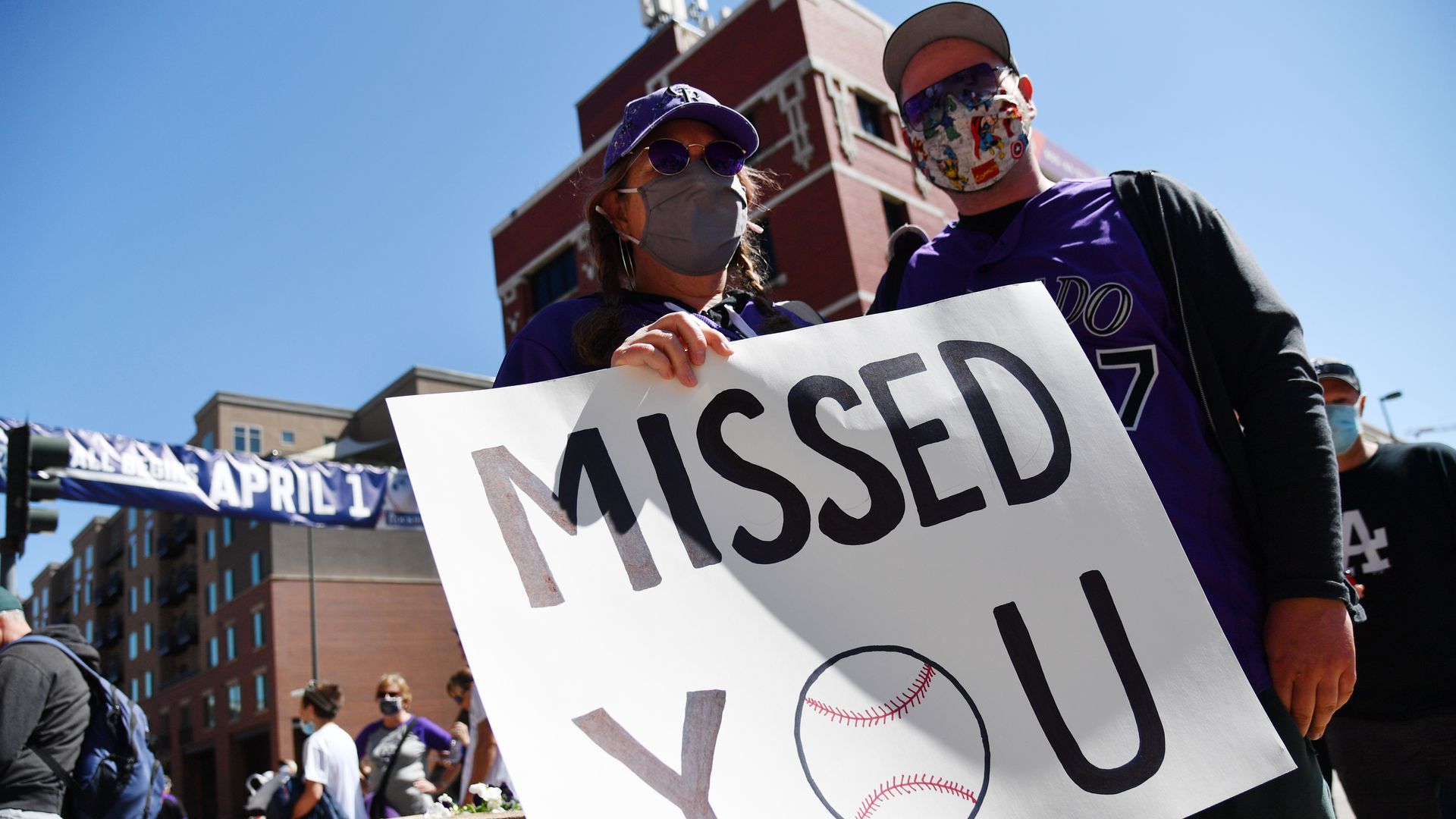 Two baseball fans hold a sign that reads Missed You