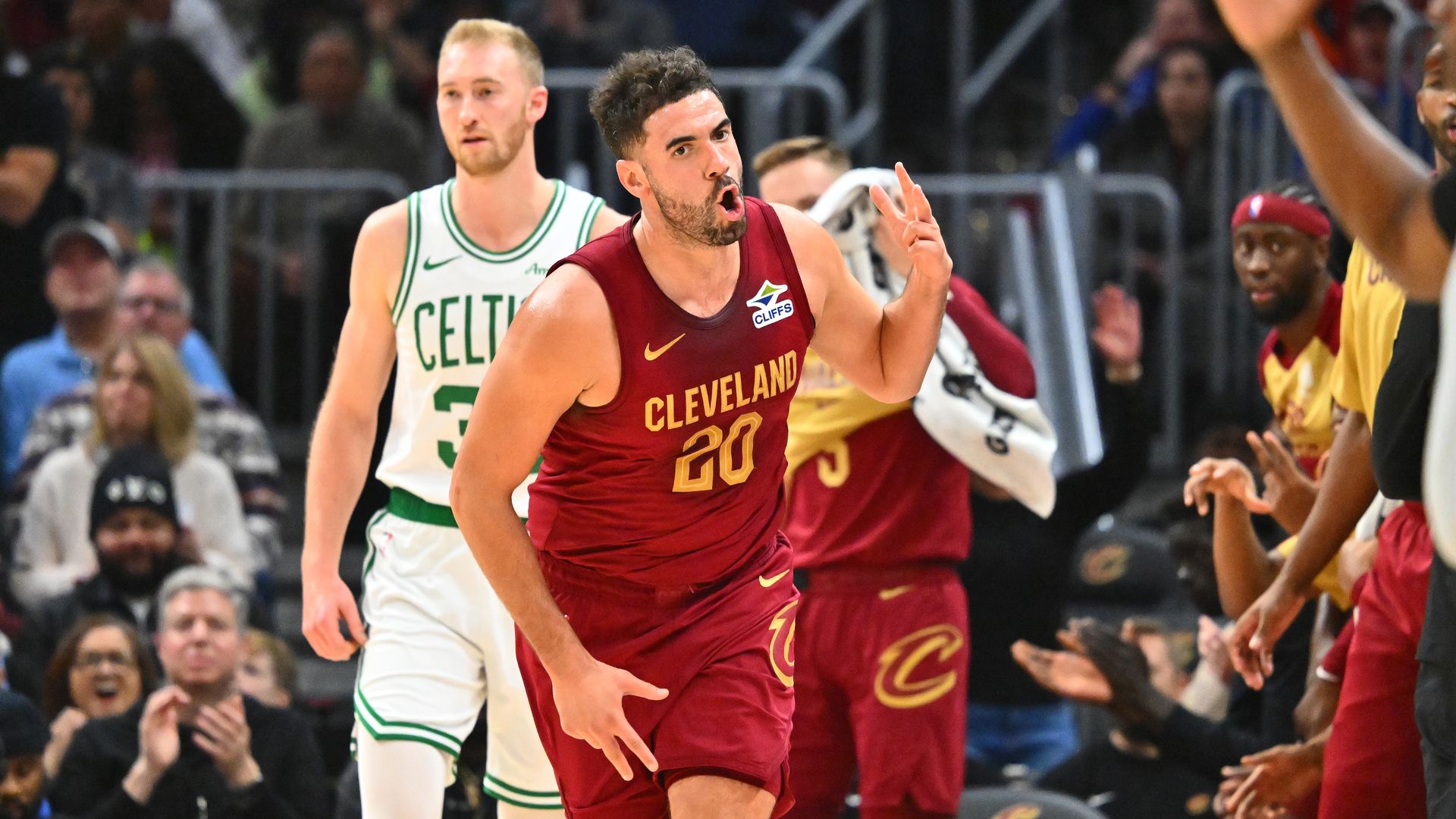 Photo of Cavs Georges Niang in red jersey running down court making face