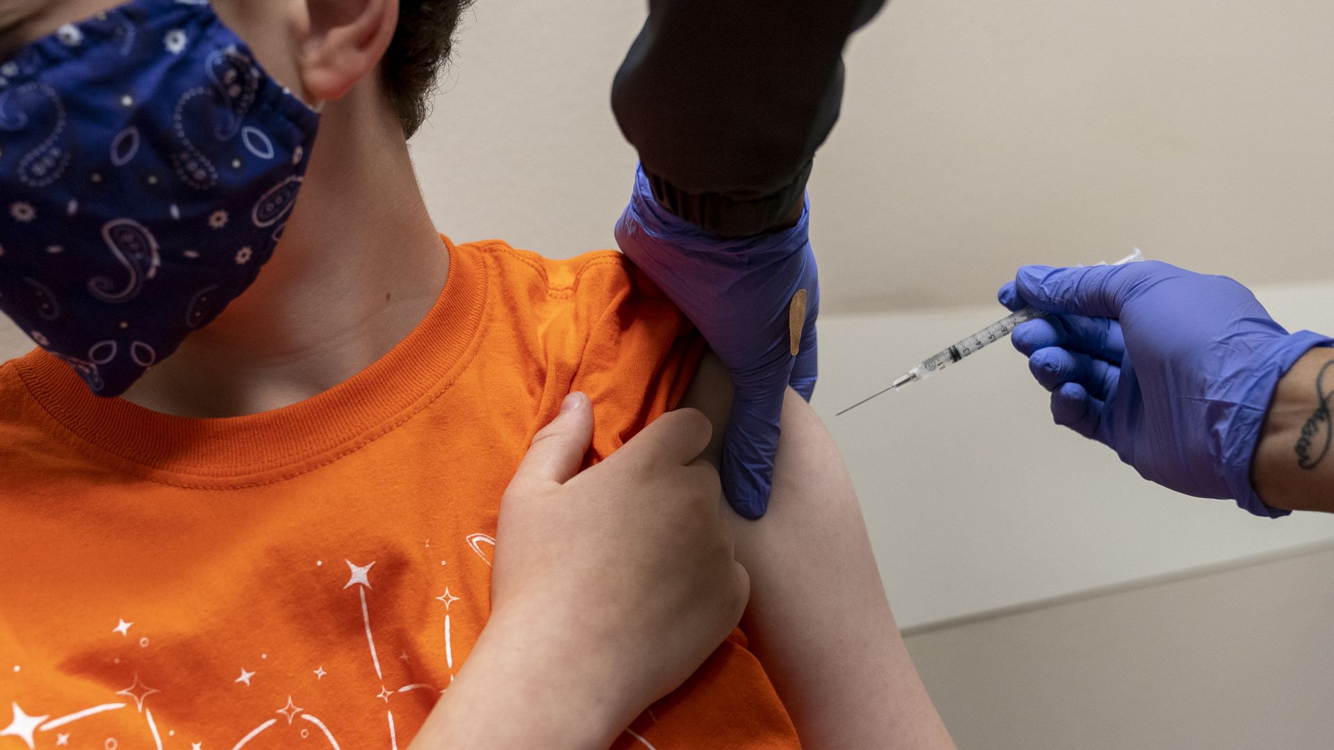 A healthcare worker administers a dose of the Pfizer-BioNTech Covid-19 vaccine to a child at an Oklahoma County Health Department Vaccine Clinic.
