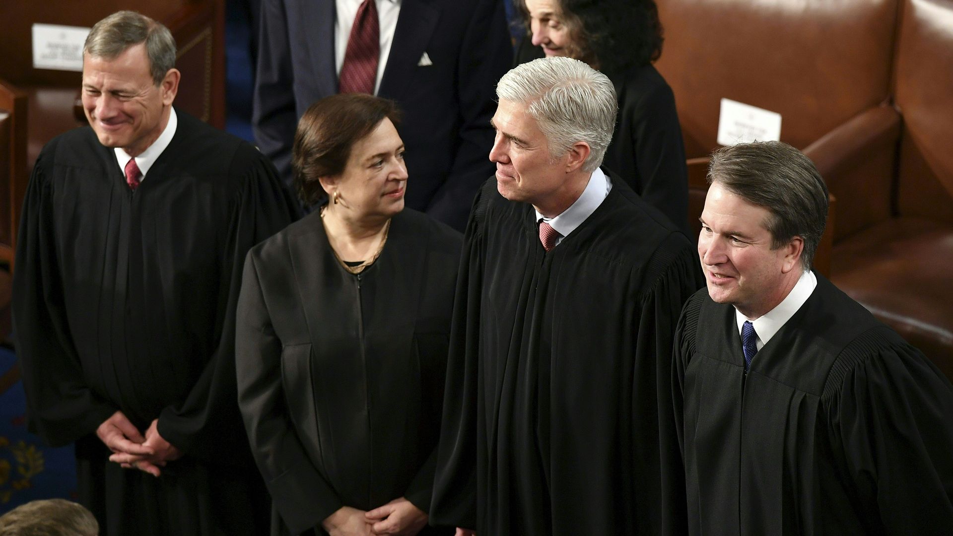 In this image, the Supreme Court justices stand in a line 