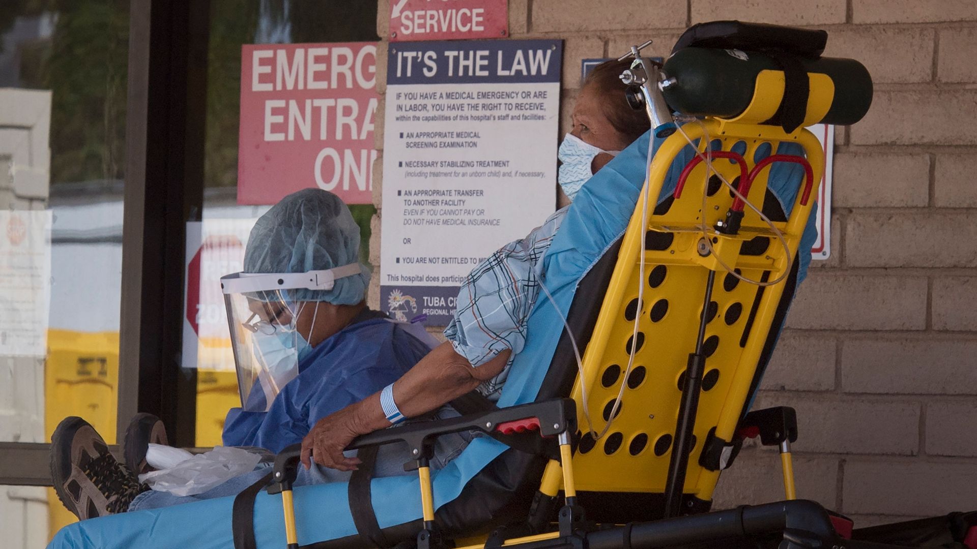 A woman on a stretcher entering a hospital. 