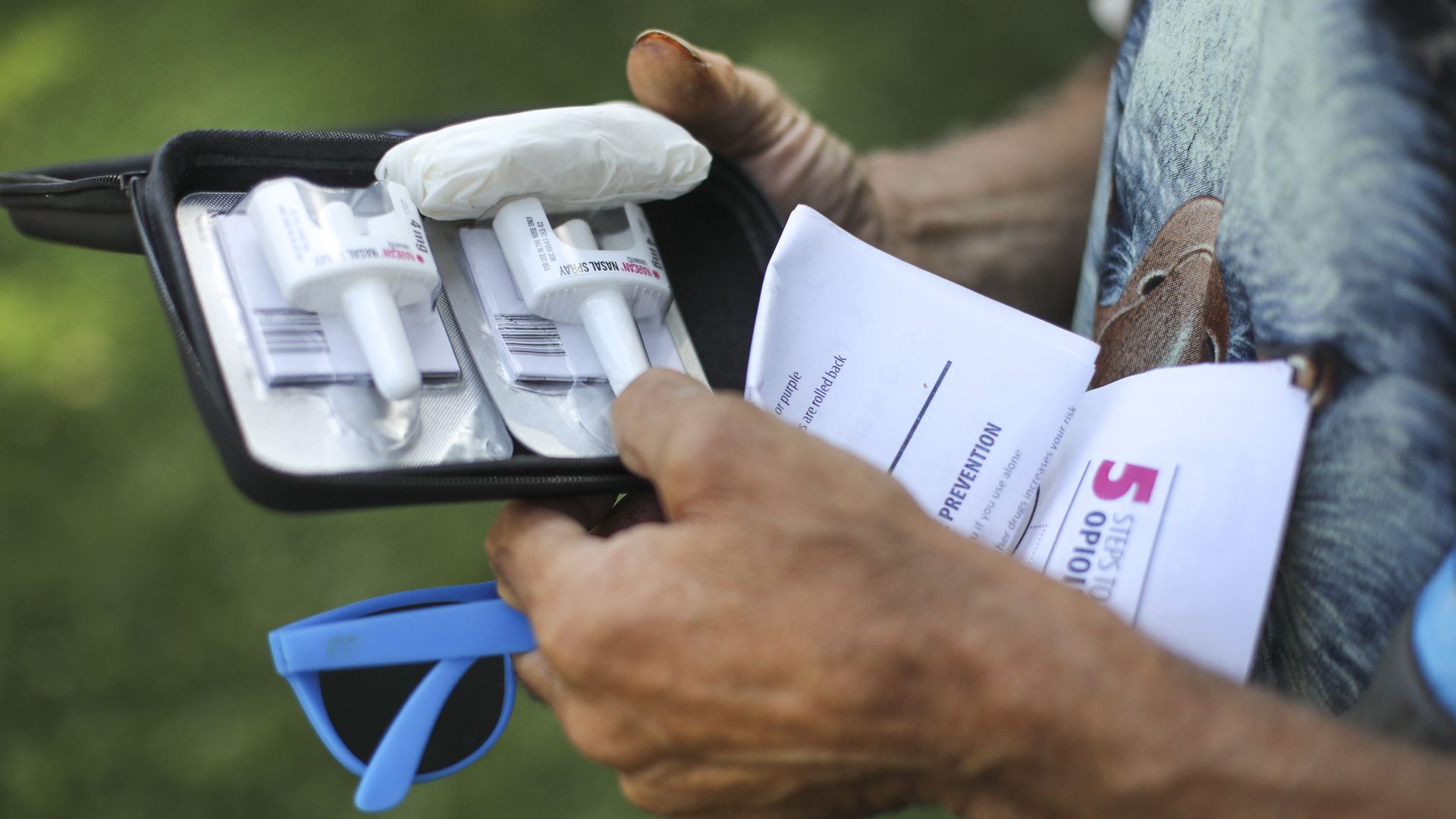 A person holding a Naloxone kit