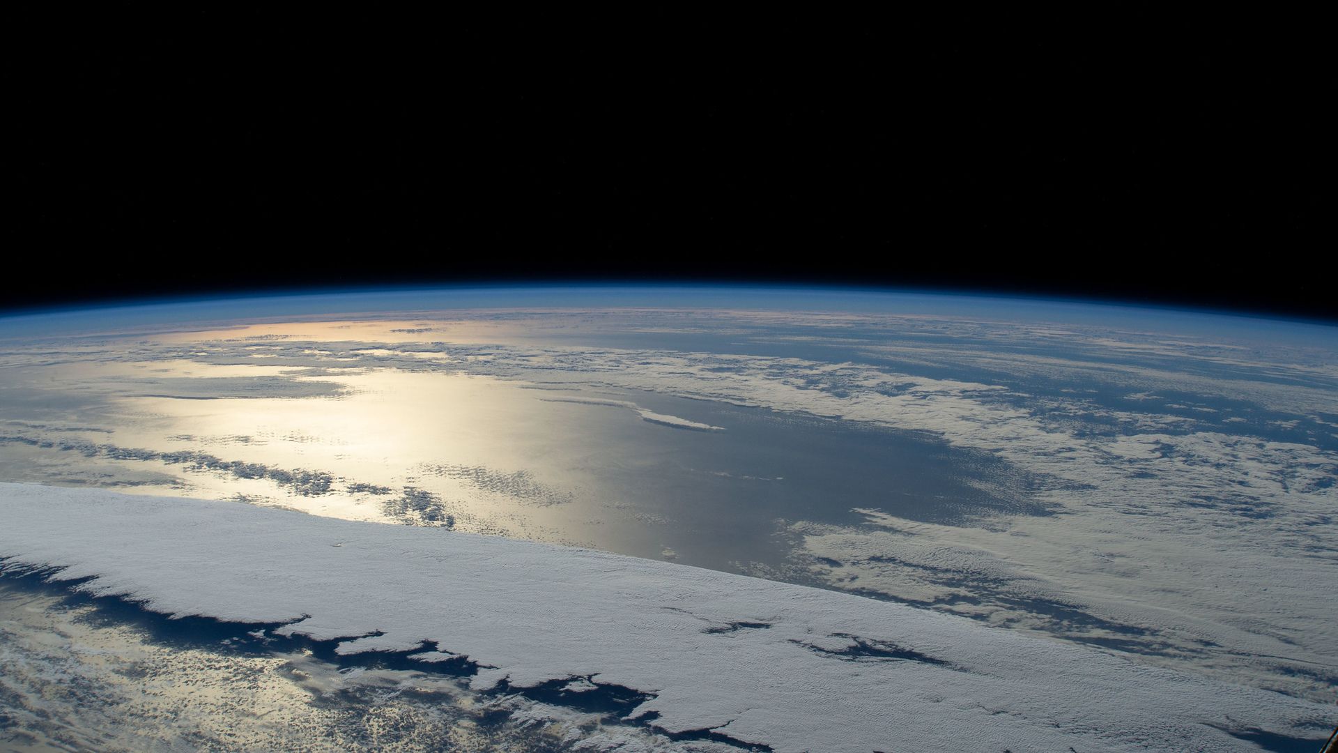 The Sun glints off the Pacific Ocean as seen from the International Space Station