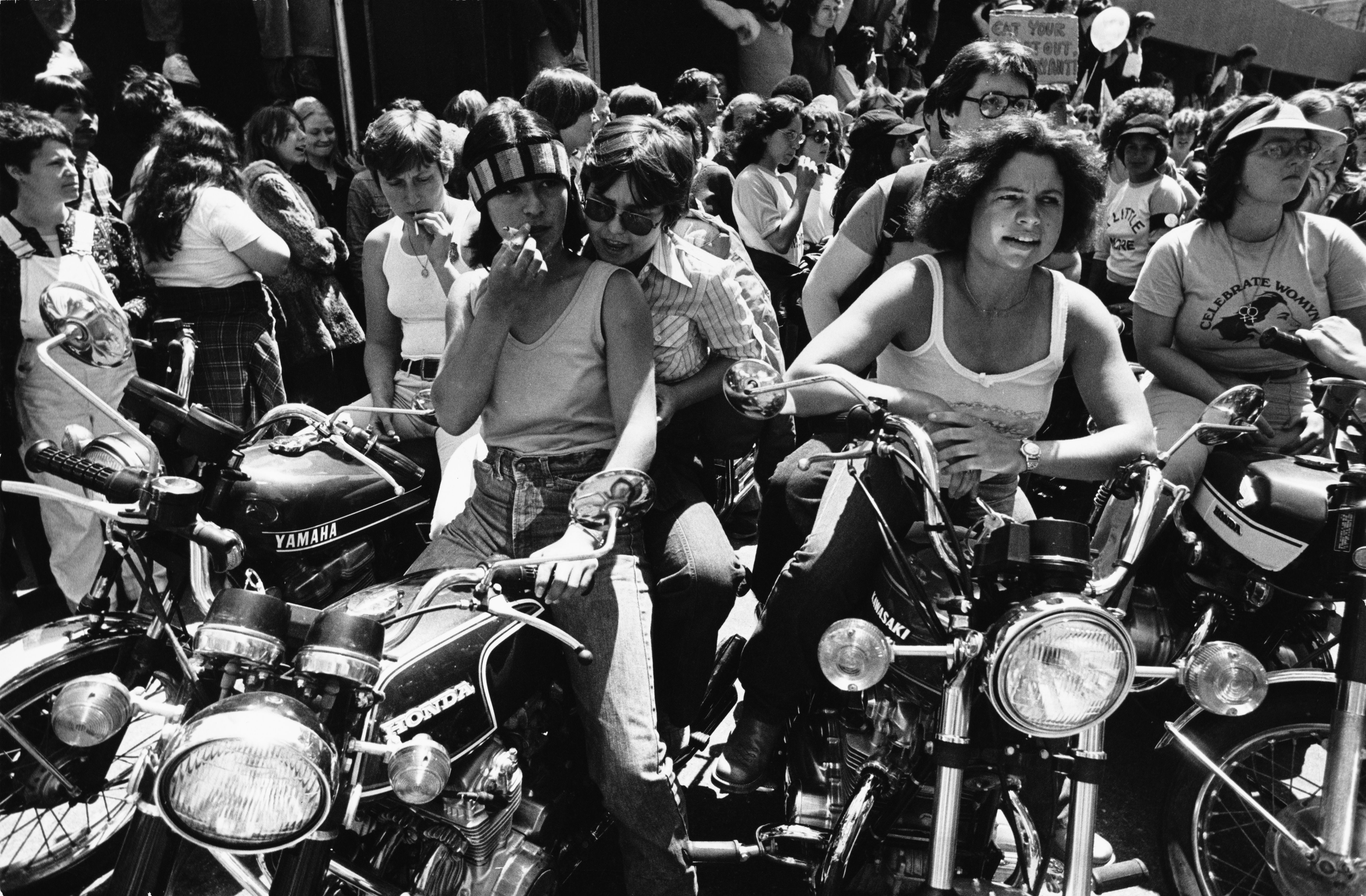 Photo of women wearing white tank tops sitting on motorcycles