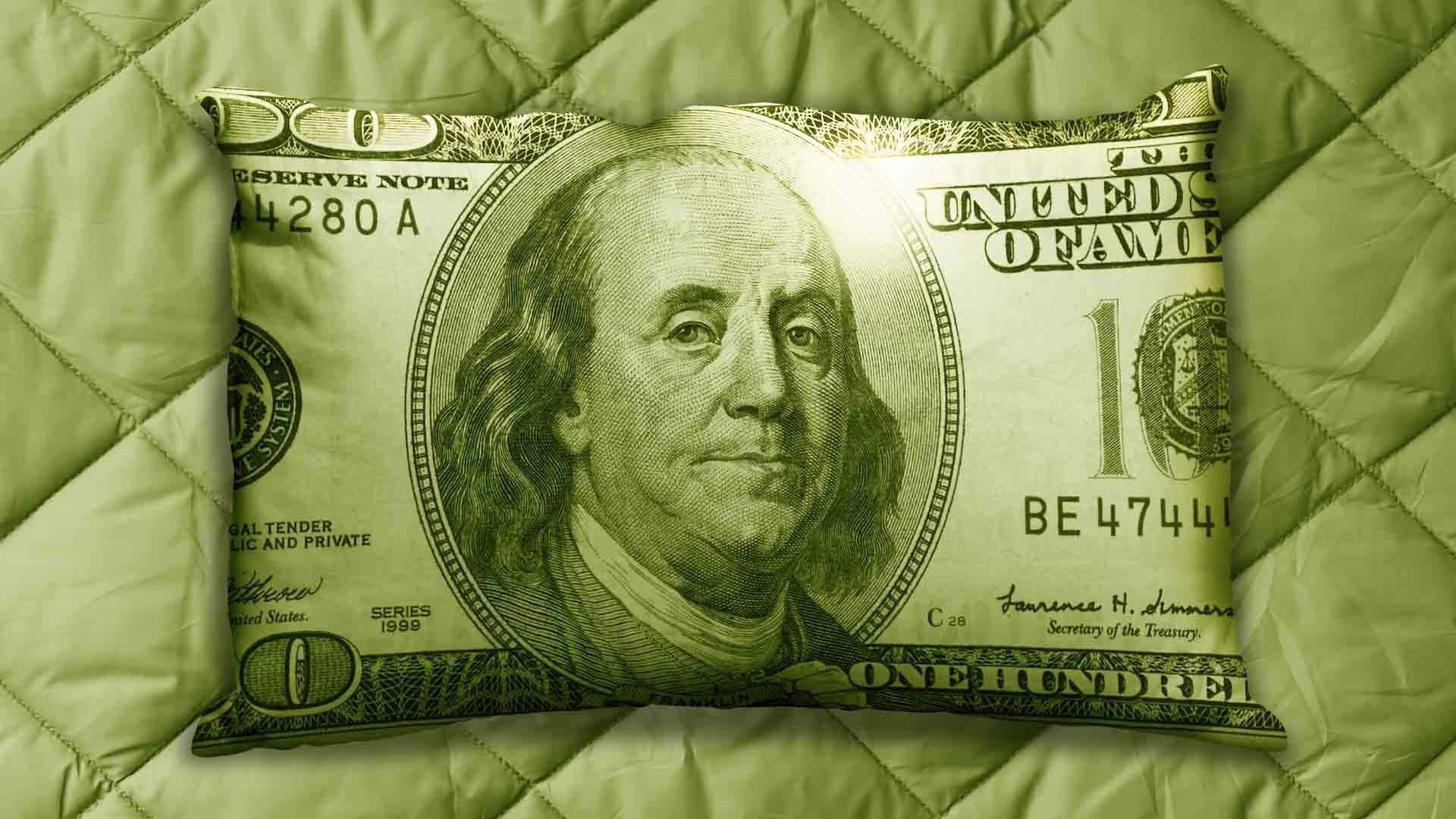 Illustration of a pillow in the shape of a hundred dollar bill on a bedspread