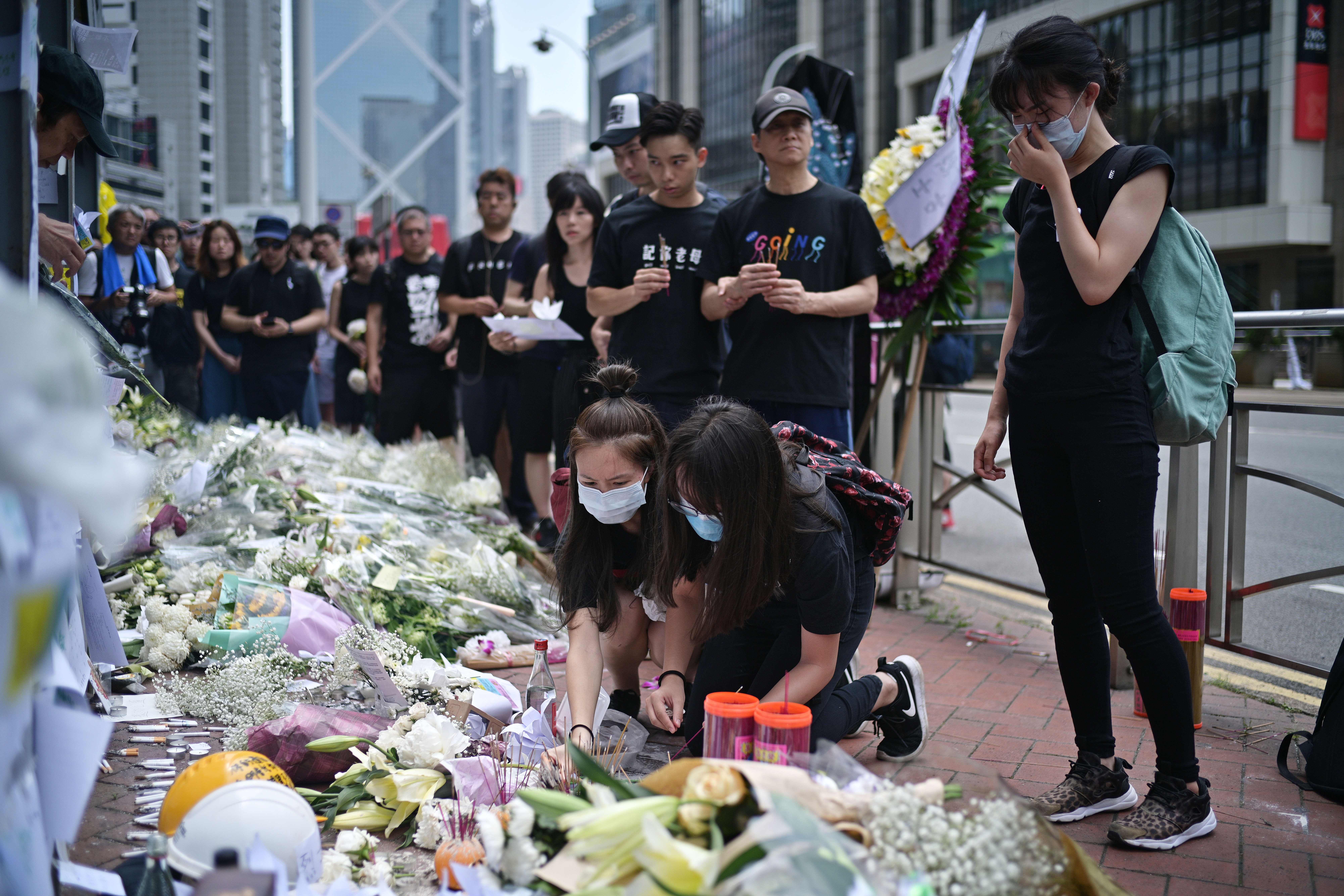 Mourners place flowers and offer prayers at the site where a protester died, prior to the start of a rally in Hong Kong on June 16, 2019. 