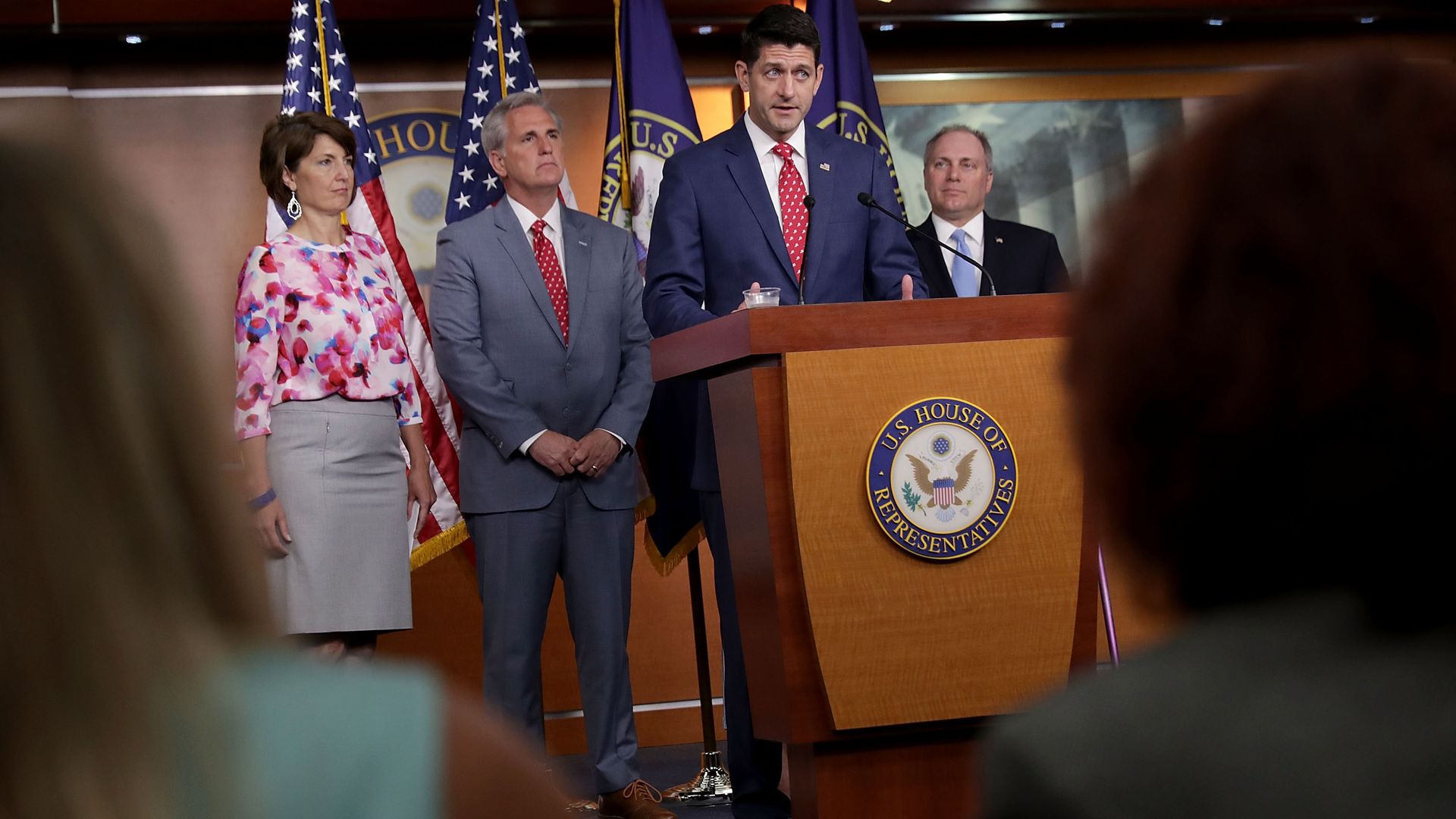 Paul Ryan answering questions at a podium with other GOP House leaders